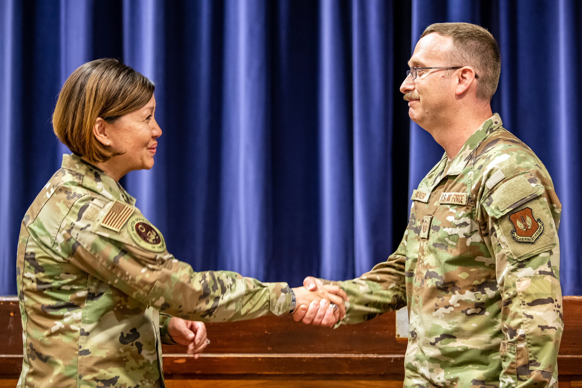 Chief Master Sgt. of the Air Force JoAnne S. Bass coins Master Sgt. Jeffrey Fauver, 422d Communications Squadron satcom gateway manager, during an all-call at RAF Croughton, England, July 12, 2023. The all-call covered the Air Force’s strategic priorities, the future of pay and benefits for Airmen and the importance of posturing for future warfighting operations. Additionally, the visit from CMSAF gave her the opportunity to speak with and recognize Airmen from across the 501 CSW. (U.S. Air Force photo by Staff Sgt. Eugene Oliver)