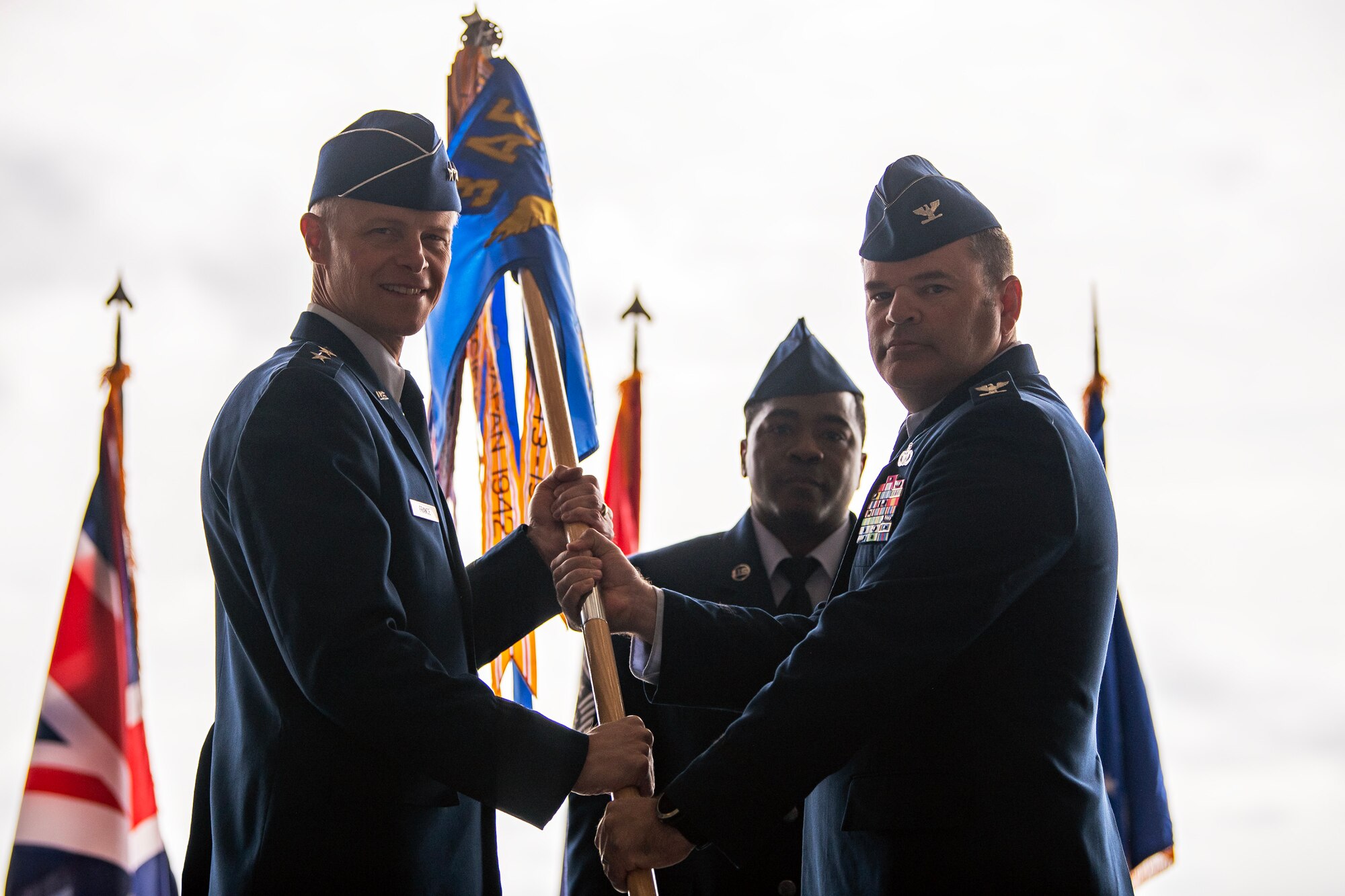U.S. Air Force Col. Brian Filler, right, relinquishes command of the 501st Combat Support Wing during a change of command ceremony at RAF Fairford, England, July 18, 2023. The passing of the guidon signifies the ceremonious transition of responsibility and command from one party to another. (U.S. Air Force photo by Staff Sgt. Eugene Oliver)