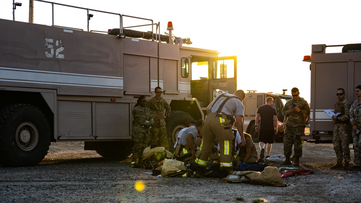 U.S. Air Force fire protection Airmen from the 386th Expeditionary Civil Engineer Squadron perform immediate first aid on a victim from a simulated aircraft crash during a medical response exercise at Ali Al Salem Air Base, Kuwait, July 17, 2023. This exercise tested the emergency response systems of U.S. and coalition forces, which allowed for a better understanding of how they can communicate and operate together in the event of a real-world emergency. (U.S. Air Force photo by Staff Sgt. Kevin Long)