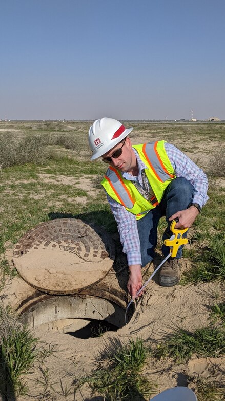 Man measuring a storm drain.