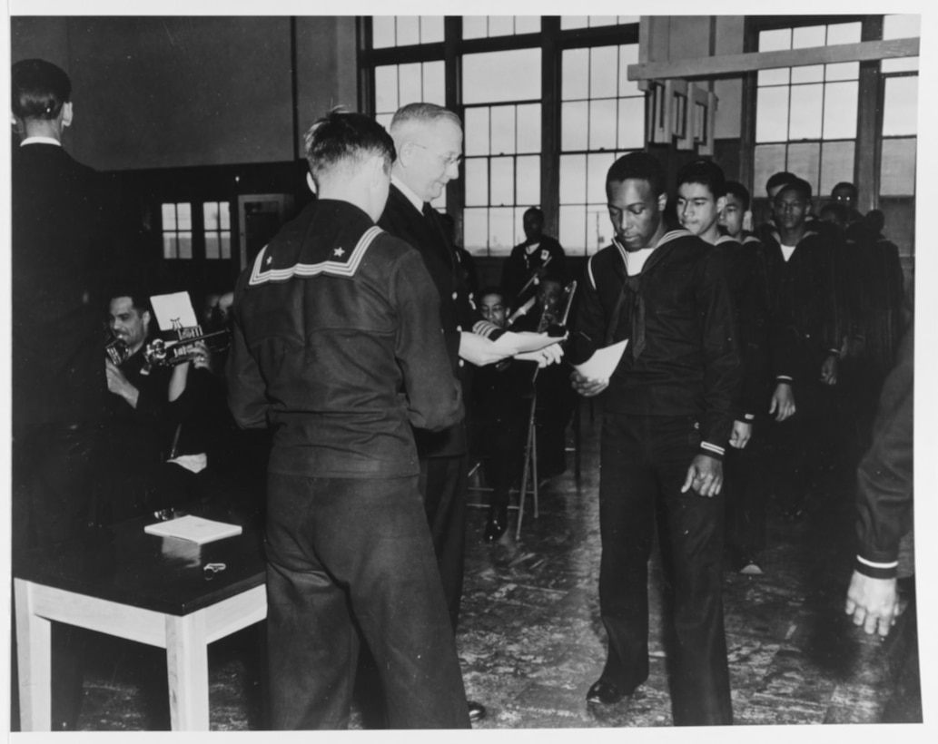 Sailors receive certificates at graduation exercises for the sixth African American class at the Great Lakes Naval Training Station, ca. April 1943.