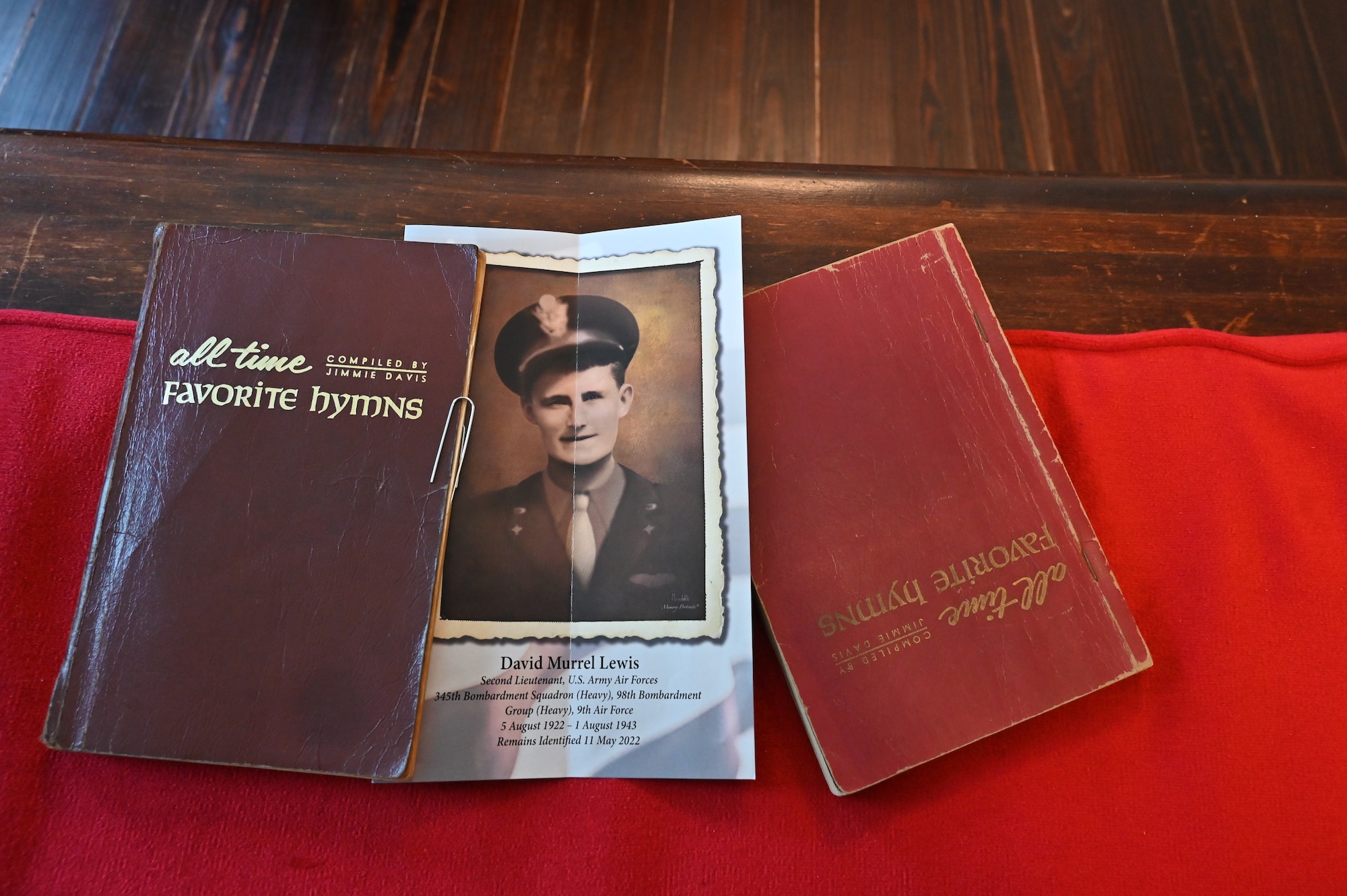 A memorial program for U.S. Army Air Force 2nd Lt. David M. Lewis lies with hymnals on a church pew.
