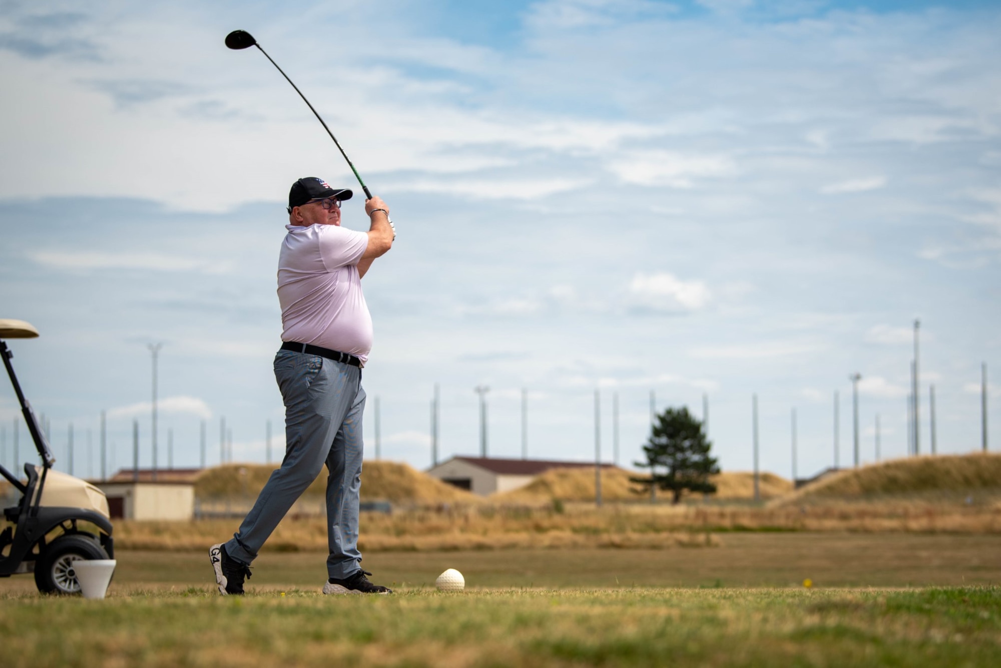 Piotr Wojtczak, Polish Ambassador to Luxembourg, swings at a golf ball during a tournament