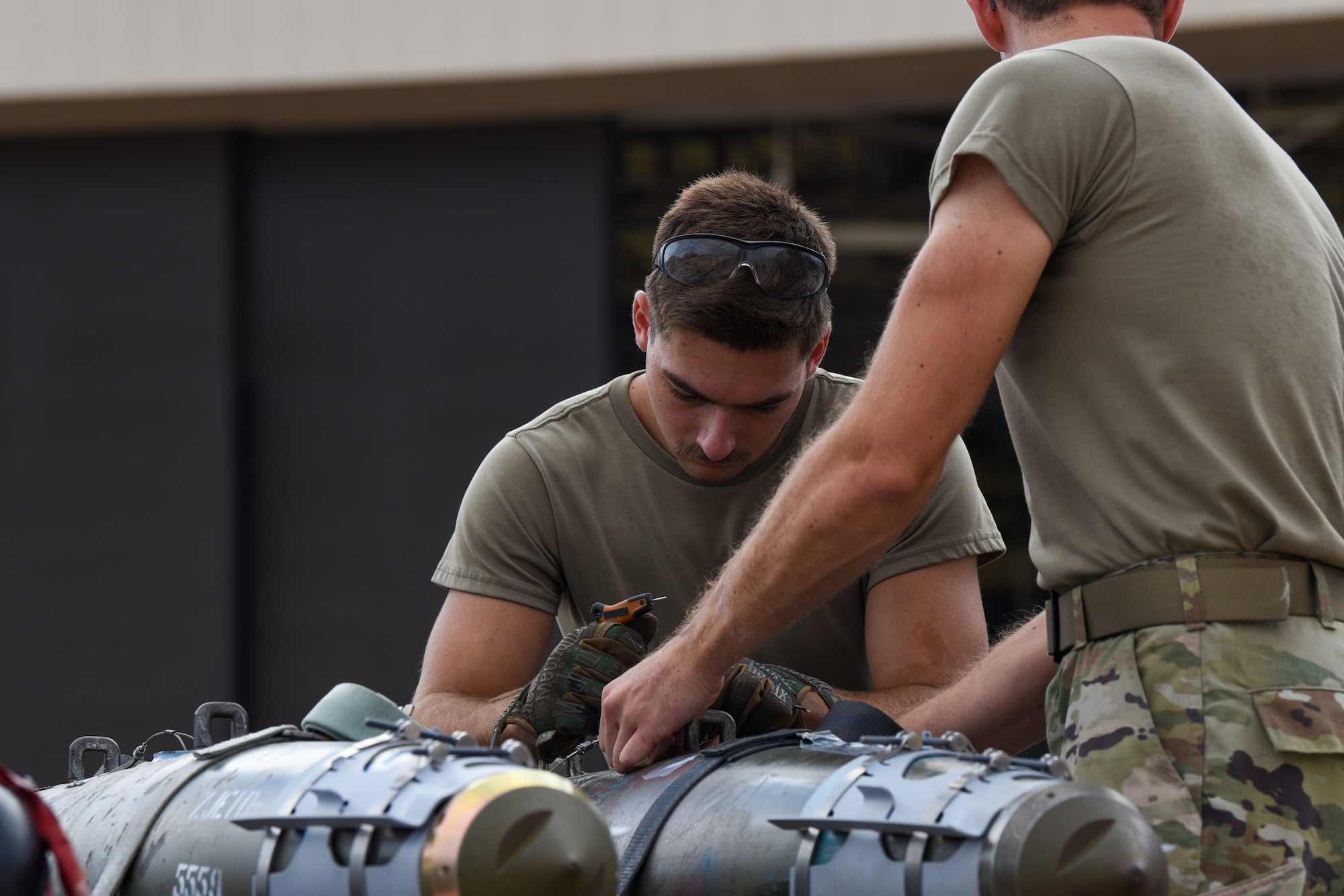 U.S. Air Force Senior Airmen Tyler Coburn and Senior Airman Easton Gragg, 7th Munitions Squadron munitions technicians, assemble an inert Joint Direct Attack Munition during the Lone Star Challenge at Dyess Air Force Base, Texas, July 13, 2023. Two teams competed in various components which tested the abilities of Airmen from multiple squadrons in building, preparing and loading JDAMs into the B-1B Lancer. The event was designed to exercise real-world actions the 7th Bomb Wing would do if called for no notice missions. (U.S. Air Force photo by Senior Airman Sophia Robello)