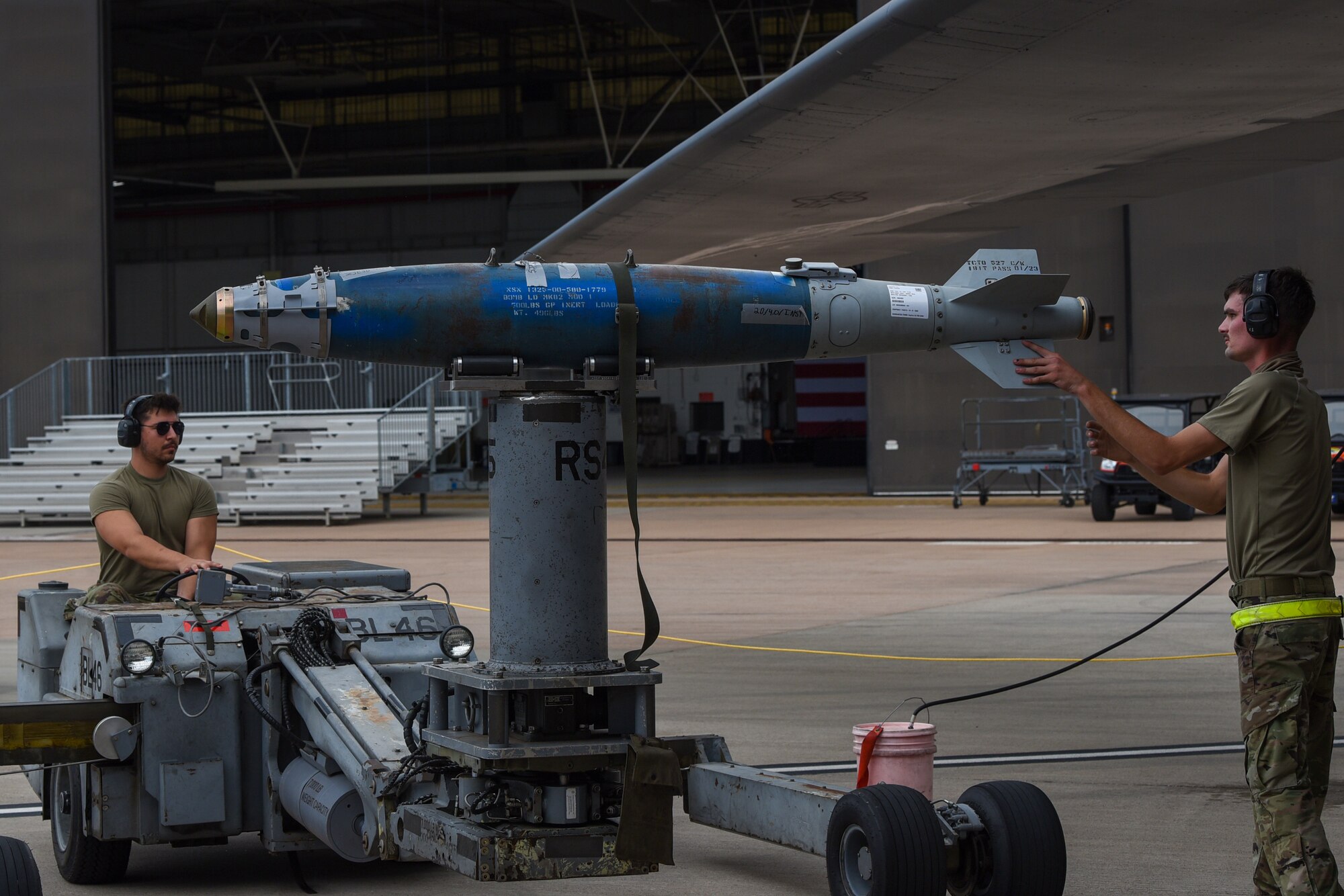 Senior Airmen Phillip Crumley and Jeremy Cornett, 7th Munitions Squadron weapons load crew members, guides a bomb lift into the weapons bay of a B-1B Lancer as part of the Lone Star Challenge at Dyess Air Force Base, Texas, July 13, 2023.  Two teams competed in various components which tested the abilities of Airmen from multiple squadrons in building, preparing and loading JDAMs into the B-1B. The event was designed to exercise real-world actions the 7th Bomb Wing would do if called for no notice missions. (U.S. Air Force photo by Senior Airman Sophia Robello)