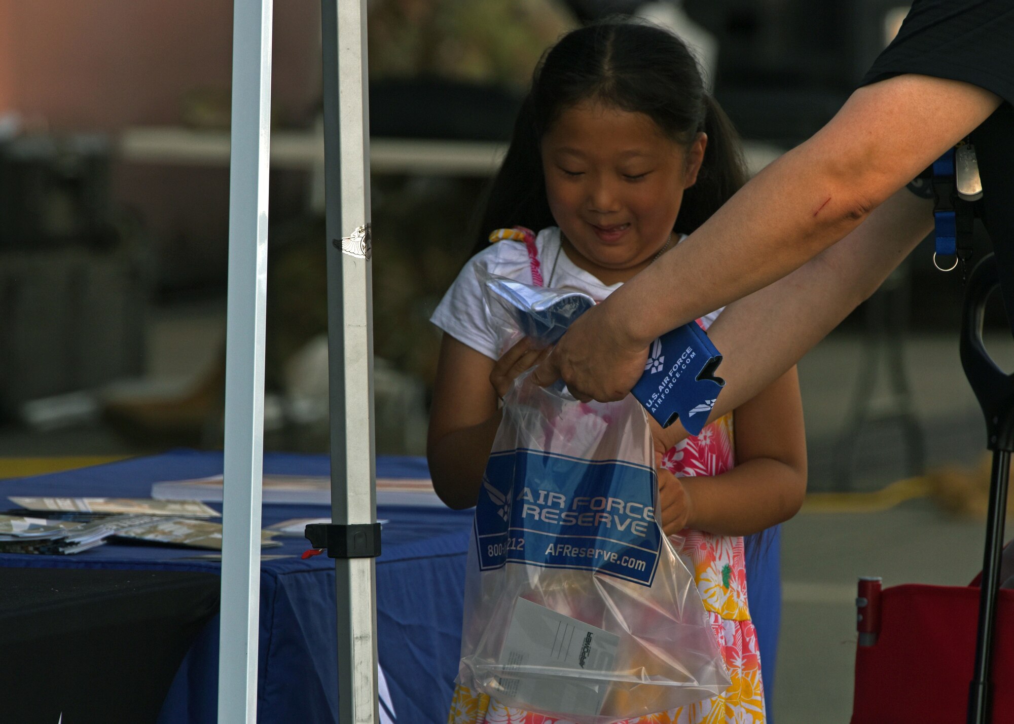 A child visits the U.S. Air Force Reserve recruiting booth during the Joint Base Lewis-McChord Airshow and Warrior Expo at JBLM, Washington, July 16, 2023. The mission of the JAWE is to foster goodwill to educate and familiarize attendees with the people, mission, and equipment of the Air Force, Army, and other Armed Services while continuing to provide installation-wide mission support. (U.S. Air Force photo by Staff Sgt. Zoe Thacker)