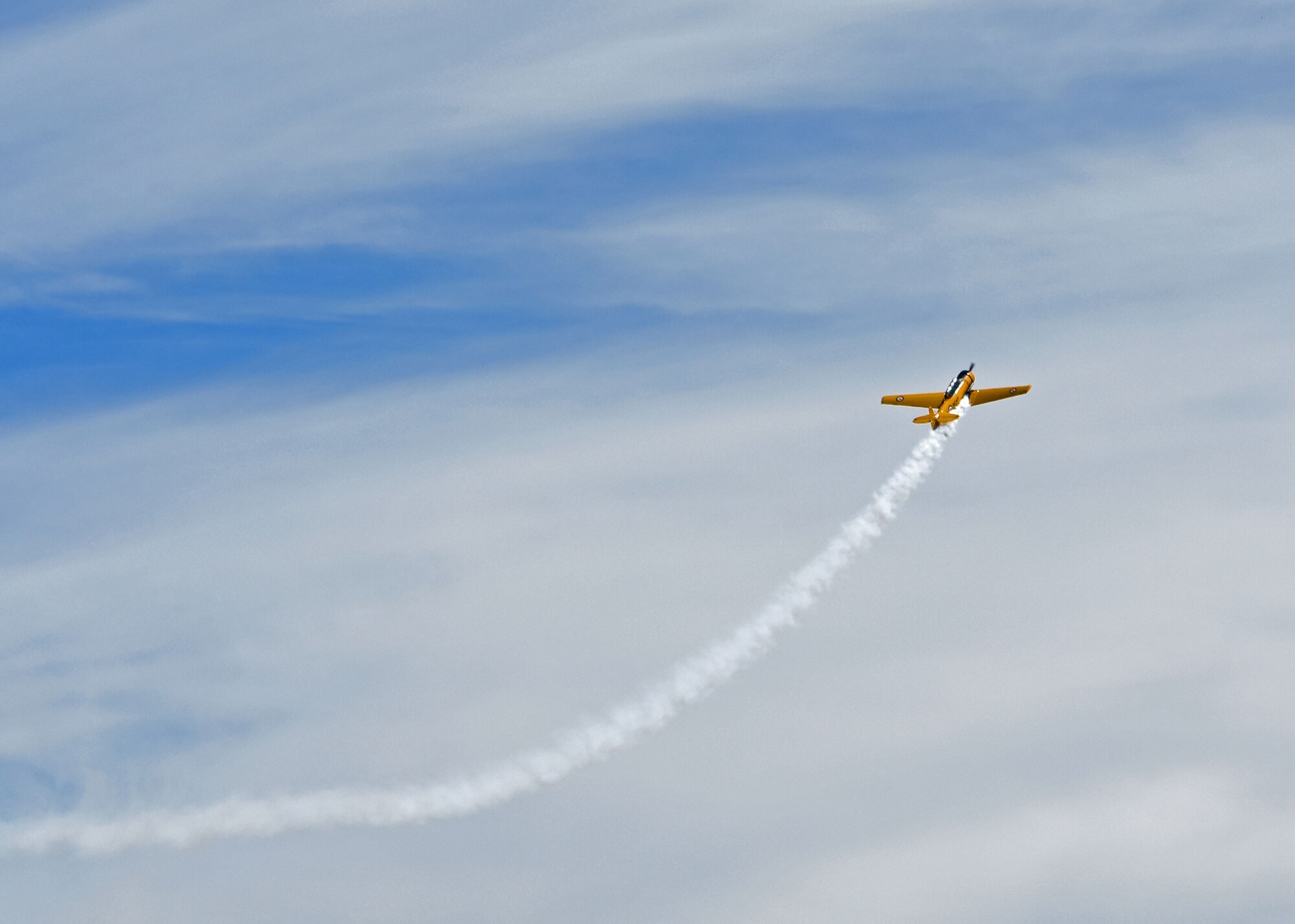 A member of the Yellow Thunder Formation Aerobatic Team flies a Harvard T-6 aircraft during the Joint Base Lewis-McChord Airshow and Warrior Expo at JBLM, Washington, July 16, 2023. The mission of the JAWE is to foster goodwill to educate and familiarize attendees with the people, mission, and equipment of the Air Force, Army, and other Armed Services while continuing to provide installation-wide mission support. (U.S. Air Force photo by Staff Sgt. Zoe Thacker)