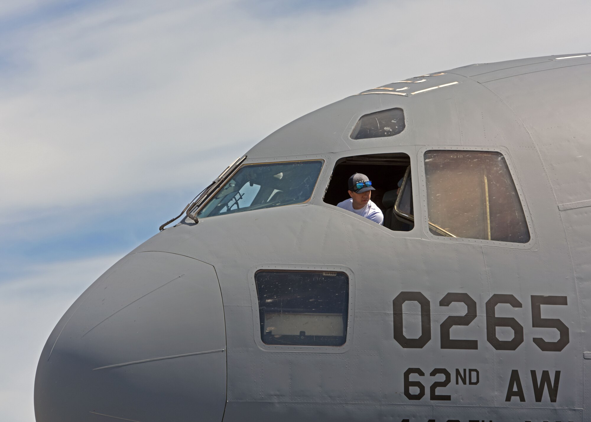 A spectator sits in the cockpit of a C-17 Globemaster III assigned to the 62d Airlift Wing during the Joint Base Lewis-McChord Airshow and Warrior Expo at JBLM, Washington, July 16, 2023. The mission of the JAWE is to foster goodwill to educate and familiarize attendees with the people, mission, and equipment of the Air Force, Army, and other Armed Services while continuing to provide installation-wide mission support. (U.S. Air Force photo by Staff Sgt. Zoe Thacker)