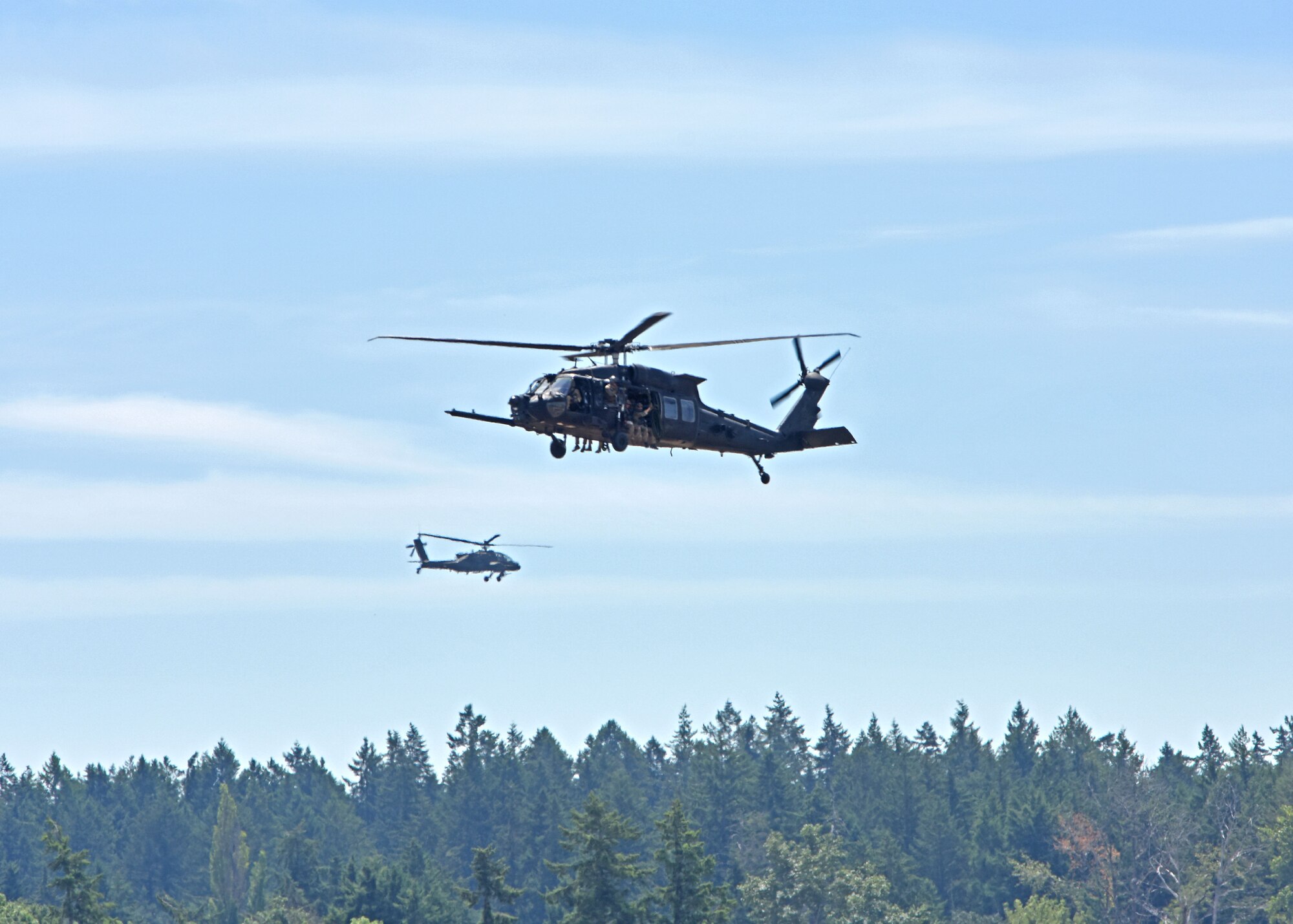 U.S. Air Force Special Tactics Airmen with the 22nd Special Tactics Squadron wave to spectators after repelling from a U.S. Army AH-64E Apache helicopter at the Joint Base Lewis-McChord Airshow and Warrior Expo at JBLM, Washington, July 16, 2023. The mission of the JAWE is to foster goodwill to educate and familiarize attendees with the people, mission, and equipment of the Air Force, Army, and other Armed Services while continuing to provide installation-wide mission support. (U.S. Air Force photo by Staff Sgt. Zoe Thacker)