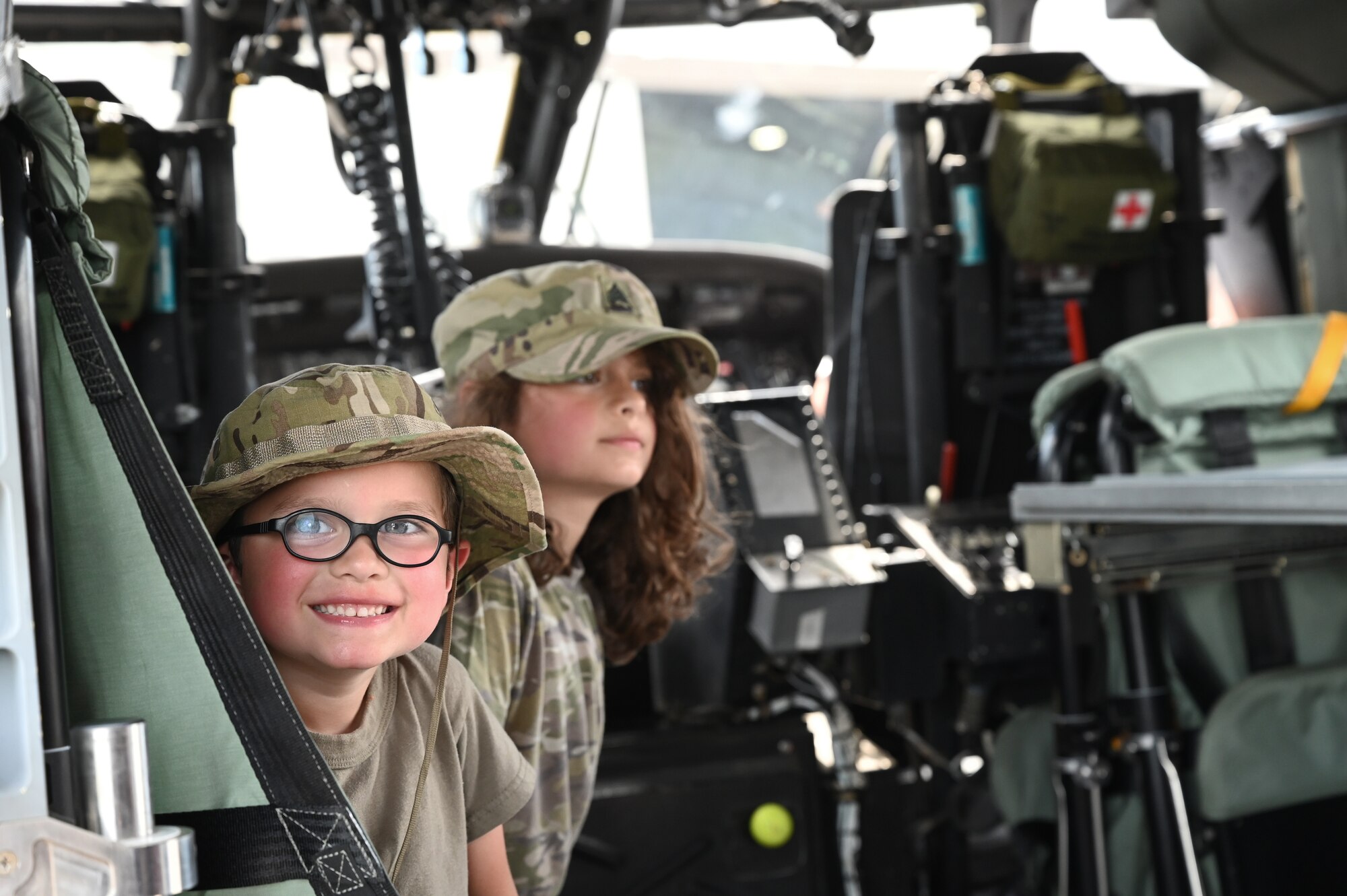 Young spectators sit in a U.S. Army HH-60L Blackhawk MEDEVAC helicopter in the distance on the McChord Field flightline during the Joint Base Lewis-McChord Airshow and Warrior Expo at JBLM, Washington, July 16, 2023. The mission of the JAWE was to foster goodwill to educate and familiarize attendees with the people, mission, and equipment of the Air Force, Army, and other Armed Services while continuing to provide installation-wide mission support. (U.S. Air Force photo by Senior Airman Colleen Anthony)