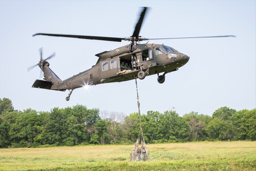 A UH-60 Black Hawk operated by Soldiers with Company C, 2nd Battalion, 147th Assault Helicopter Battalion, Iowa Army National Guard, hoists cargo for Soldiers with Company A, 628th Aviation Support Battalion, Pennsylvania Army National Guard, to conduct sling-load operationsat Camp Dodge in Johnston, Iowa, June 15, 2023.