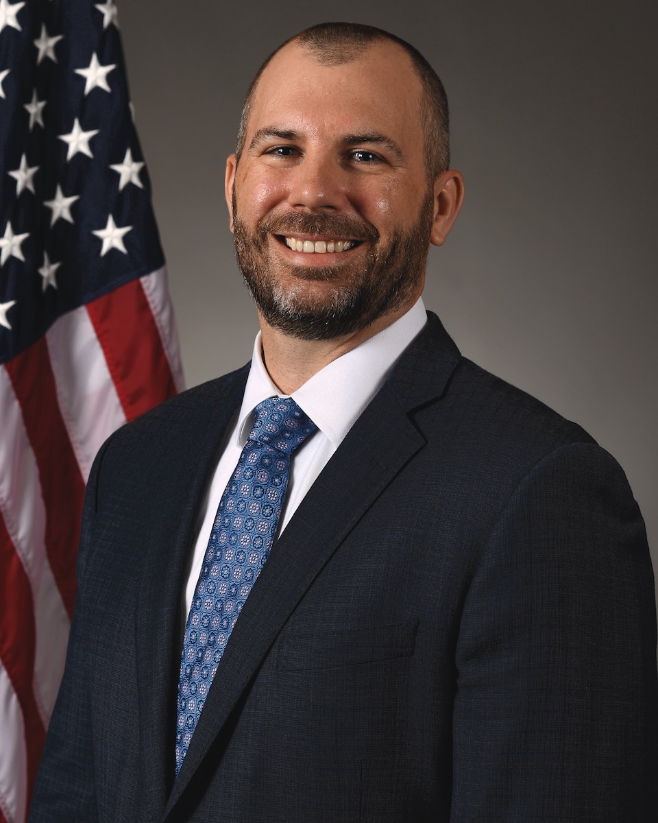 Man in suit smiles at camera