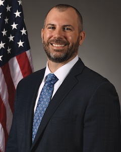 Man in suit smiles at camera