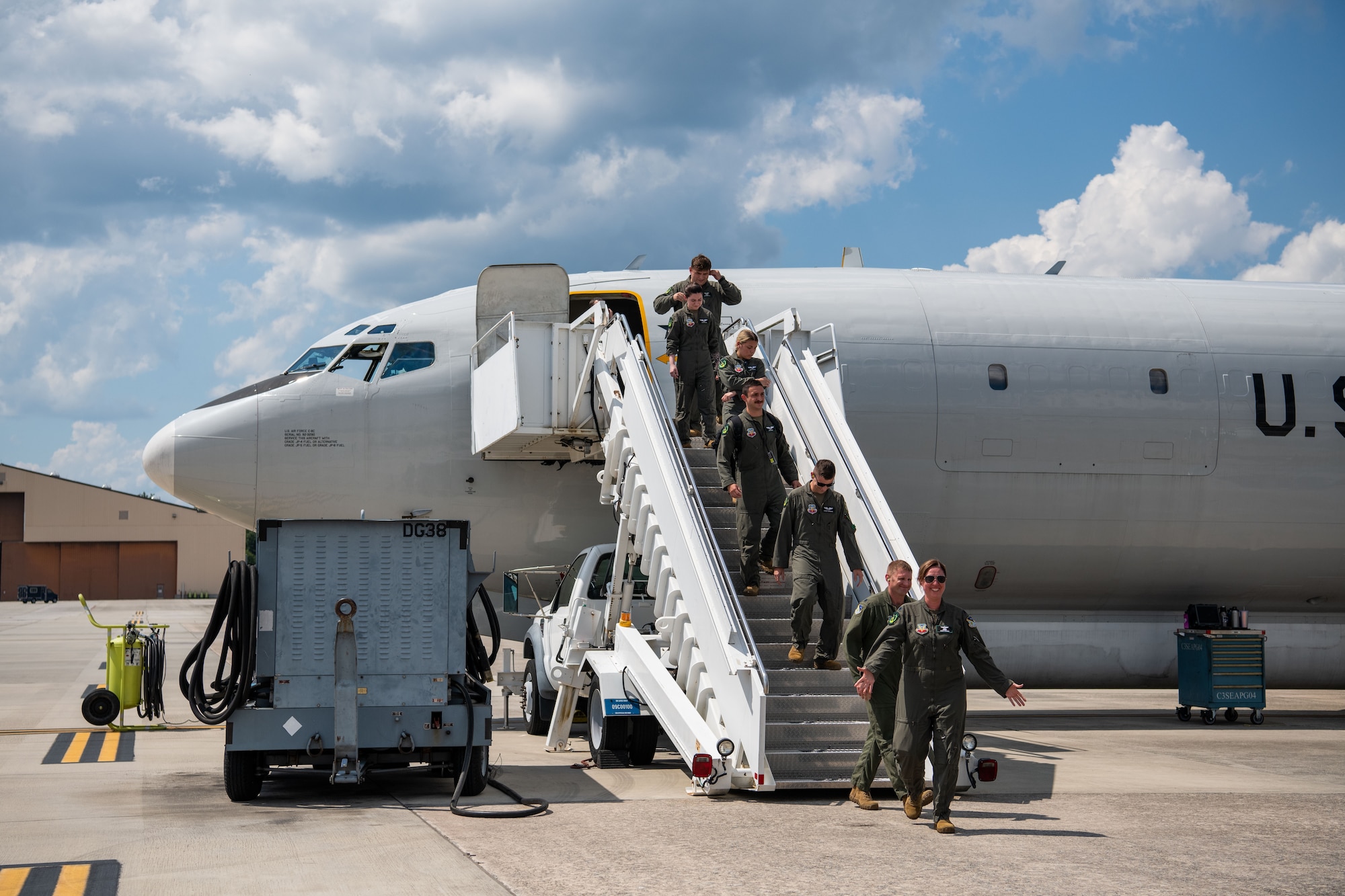 People going down stairs exiting a plane