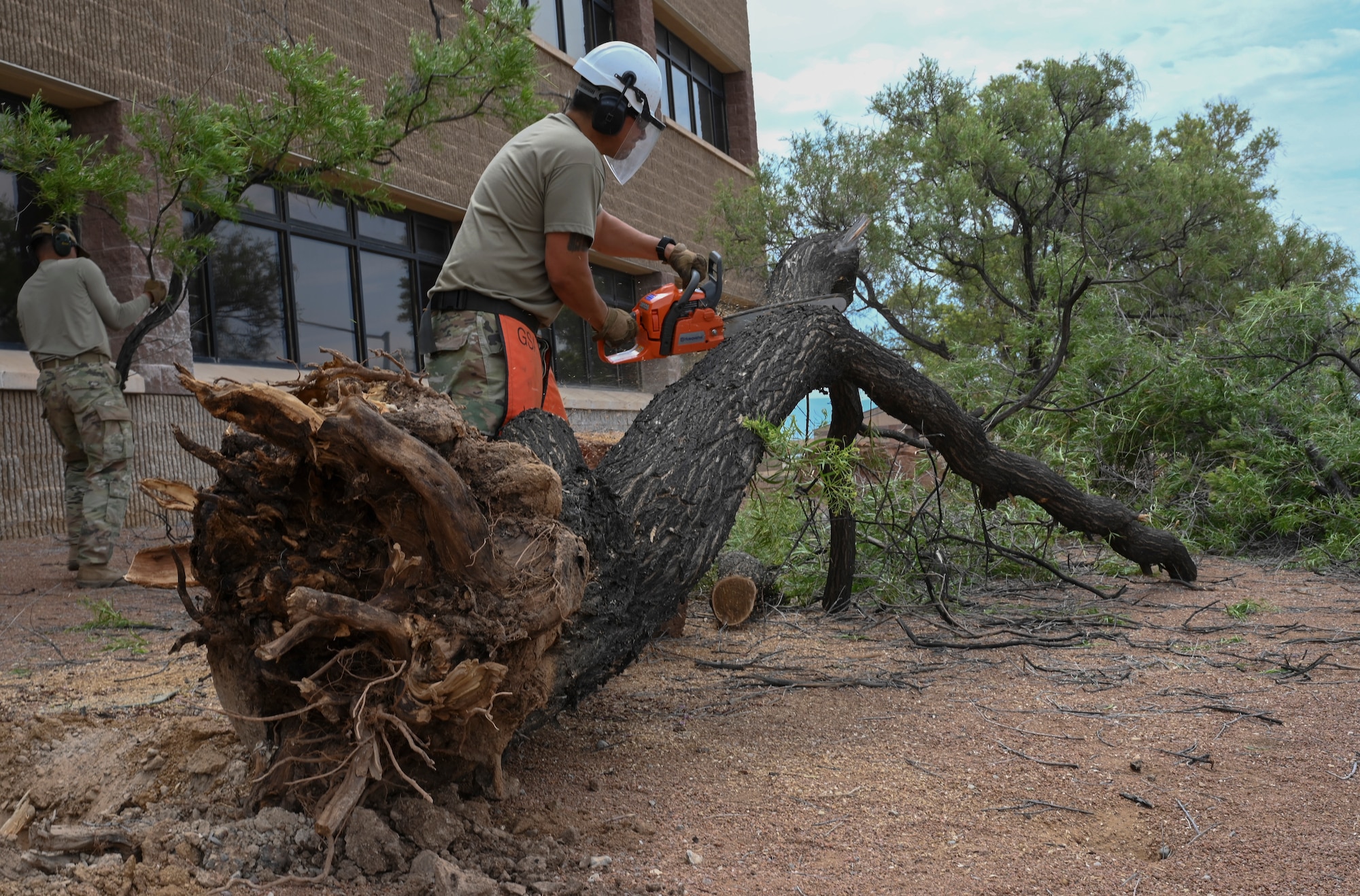 U.S. Air Force Tech. Sgt. Alonzo Marquez, 49th Civil Engineer Squadron pavements and construction equipment noncommissioned officer in charge, uses a chainsaw to remove debris of a fallen tree at Holloman Air Force Base, New Mexico, June 29, 2023. The 49th CES “Dirt Boyz” Airmen are responsible for maintaining Holloman’s infrastructure by using a variety of tools to complete construction projects. (U.S. Air Force photo by Airman 1st Class Michelle Ferrari)