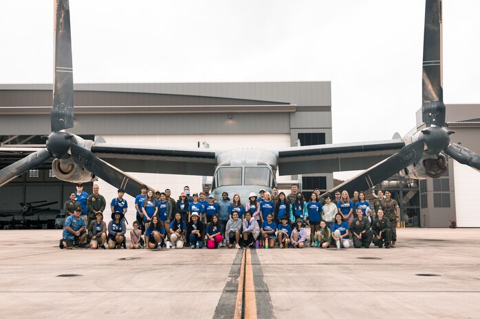 U.S. Marines with Marine Medium Tiltrotor Squadron 268, Marine Aircraft Group 24, 1st Marine Aircraft Wing, and Pearl Harbor Aviation Museum "Flight School" summer camp students pose for a group photo at Marine Corps Air Station Kaneohe Bay, Marine Corps Base Hawaii, July 11, 2023. VMM-268 partnered with the summer camp to introduce middle school students to the aviation career field and enhance community relations.