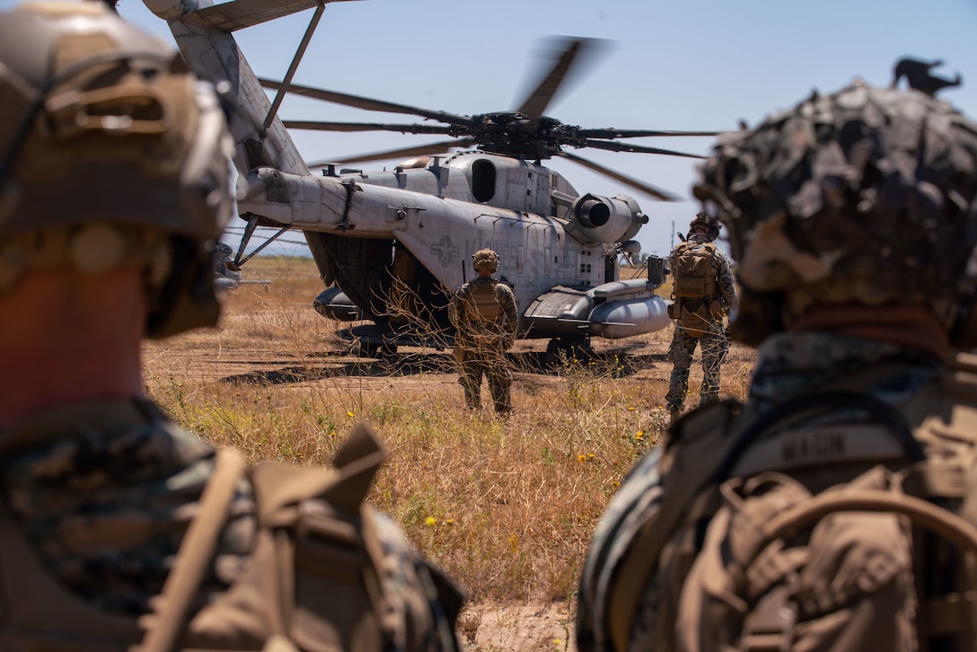 U.S. Marines assigned to Bravo Company, Battalion Landing Team 1/5, 15th Marine Expeditionary Unit, wait to board a CH-53E Super Stallion attached to Marine Medium Tiltrotor Squadron (VMM) 165 (Reinforced), 15th MEU, during tactical recovery of aircraft and personnel training at Marine Corps Base Camp Pendleton, California, June 27, 2023. The training, part of the I Marine Expeditionary Force Expeditionary Operations Training Group TRAP course, develops the capabilities of the TRAP force to enhance their capabilities recover aircraft, personnel, and equipment in austere environments. (U.S. Marine Corps photo by Lance Cpl. Kahle)