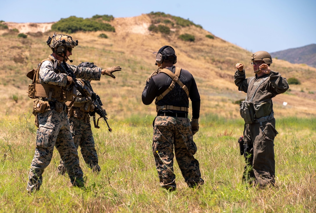 U.S. Marines assigned to Bravo Company, Battalion Landing Team 1/5, 15th Marine Expeditionary Unit, discuss identification and recovery procedures of a simulated downed pilot during tactical recovery of aircraft and personnel training at Marine Corps Base Camp Pendleton, California, June 27, 2023. The training, part of the I Marine Expeditionary Force Expeditionary Operations Training Group TRAP course, develops the capabilities of the TRAP force to enhance their capabilities recover aircraft, personnel, and equipment in austere environments. (U.S. Marine Corps photo by Lance Cpl. Kahle)