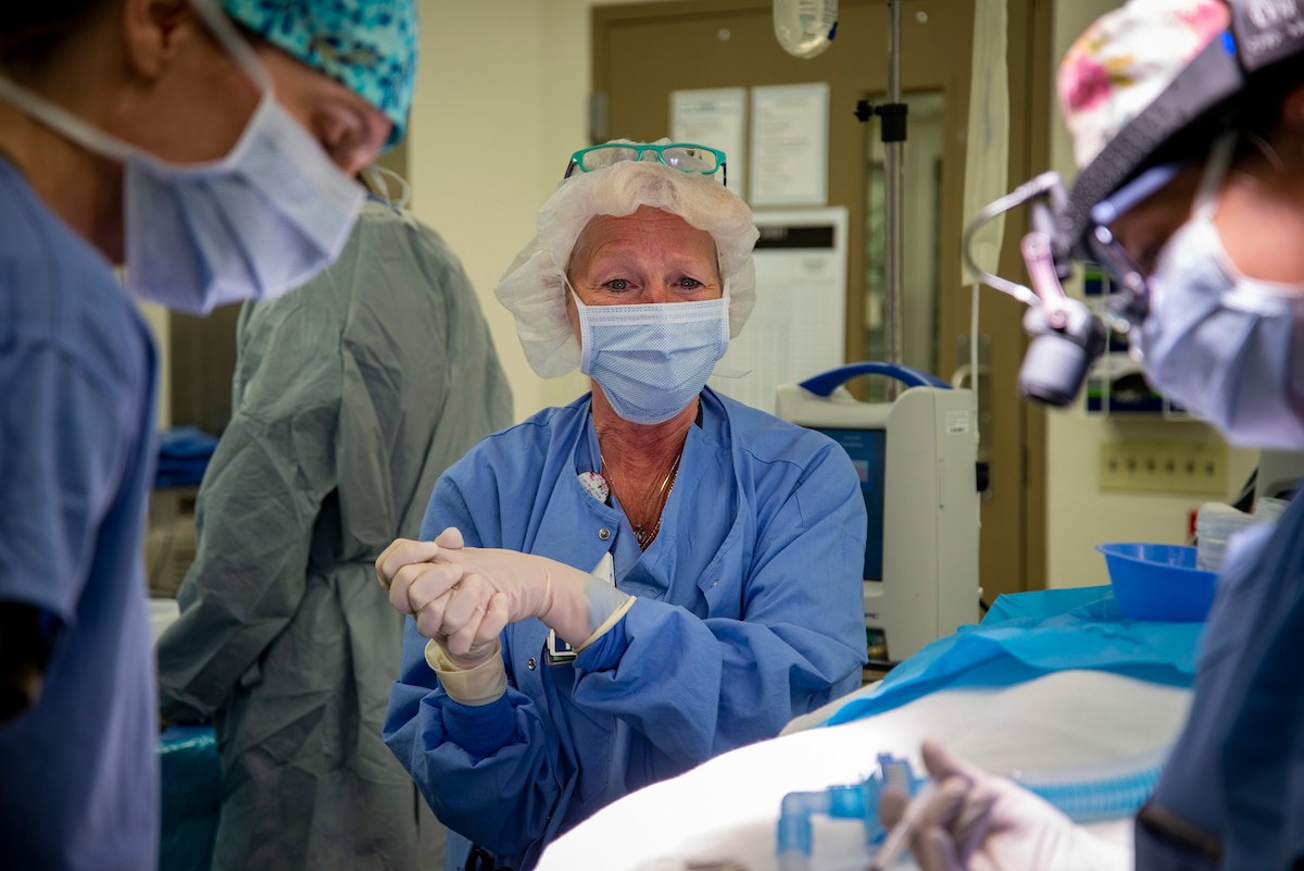 A nurse observes a surgery.