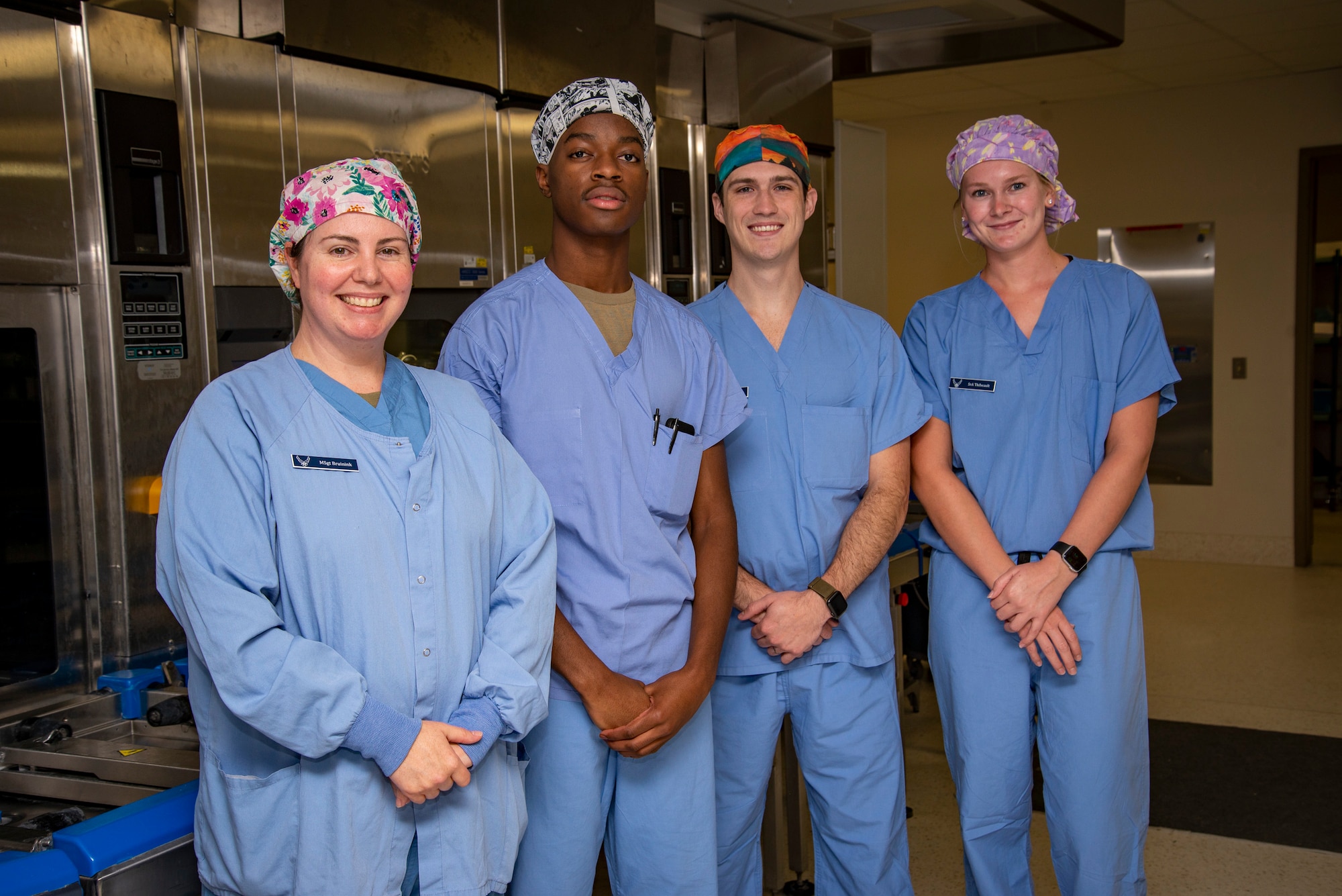 Four Airmen in medical scrubs pose for a photograph inside Wright-Patterson Medical Center.