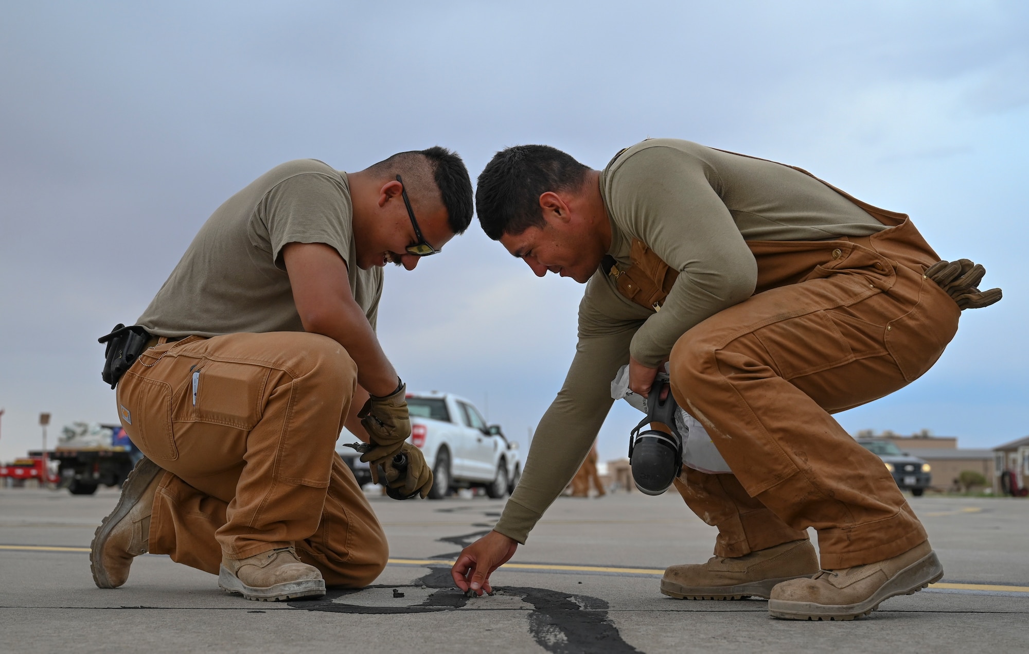 U.S. Air Force Airman 1st Class Aaron Escoto, left, and U.S. Air Force Airman 1st Class Jorge Capistran, 49th Civil Engineer Squadron pavement and construction equipment journeymen, inspect sealant installed during a previous pavement repair at Holloman Air Force Base, New Mexico, June 30, 2023. The 49th CES “Dirt Boyz” Airmen are responsible for maintaining Holloman’s infrastructure by using a variety of tools to complete construction projects. (U.S. Air Force photo by Airman 1st Class Michelle Ferrari)