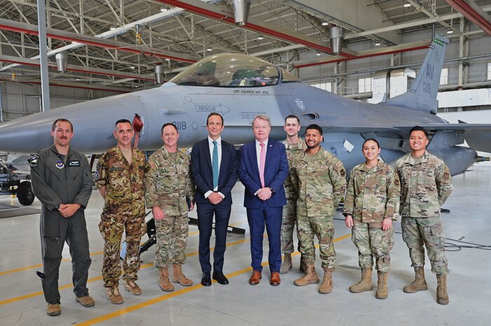 a group of people in front of a jet