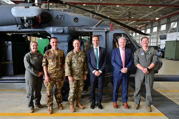 a group of people in front of a helicopter