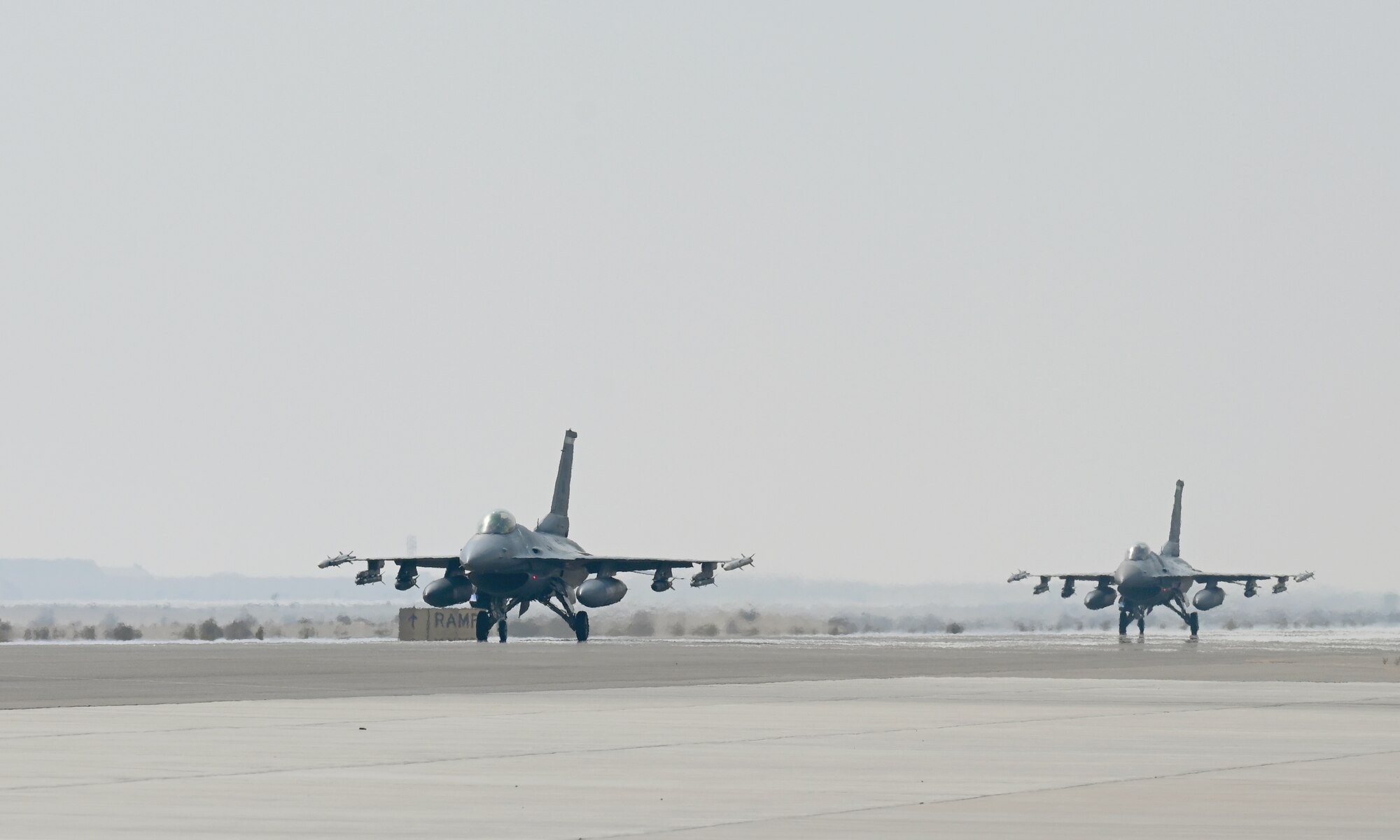 A photo of a two jets taxing on a flightline.