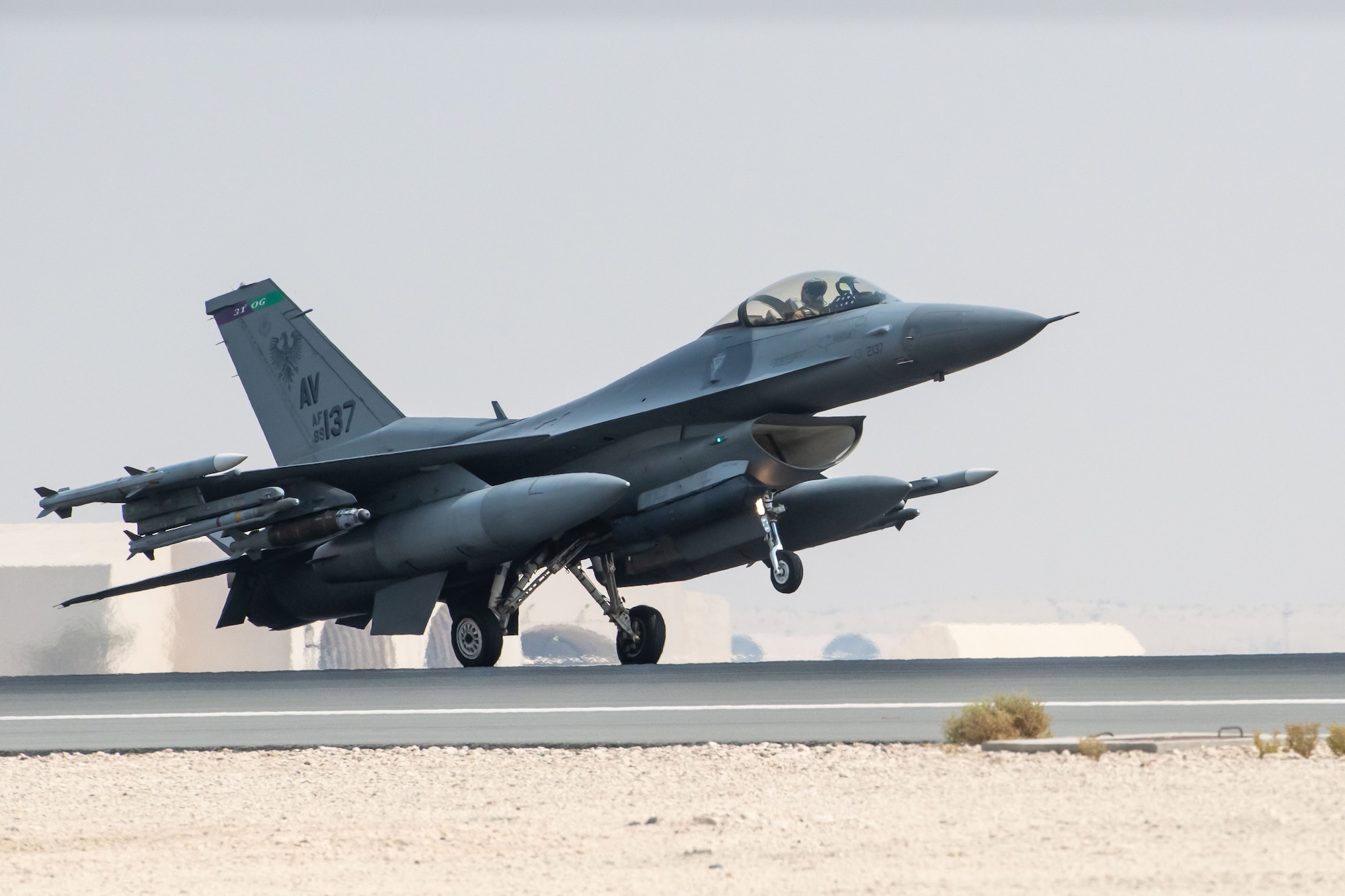 A photo of a jet landing on a flightline.