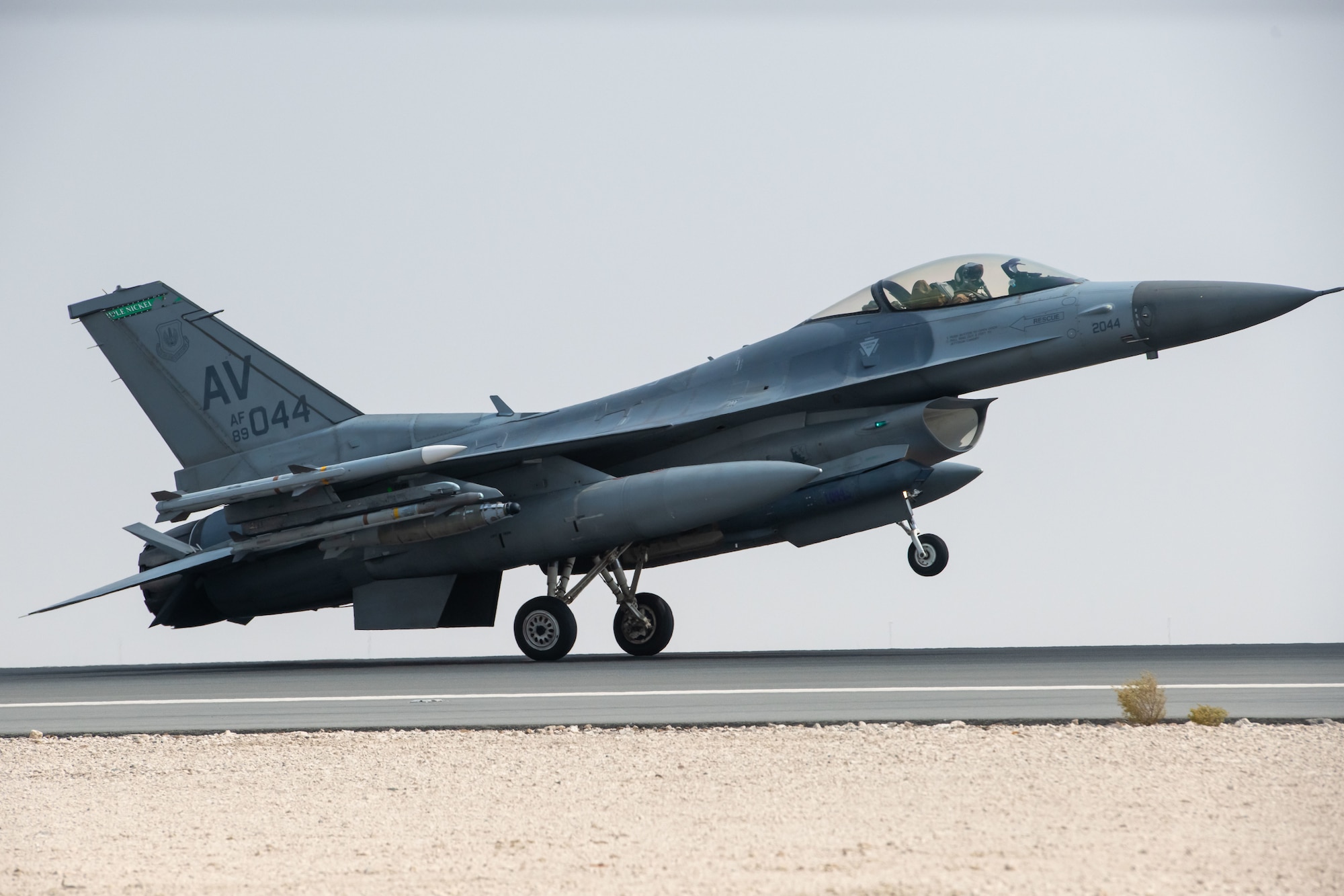 A photo of a jet landing on a flightline.