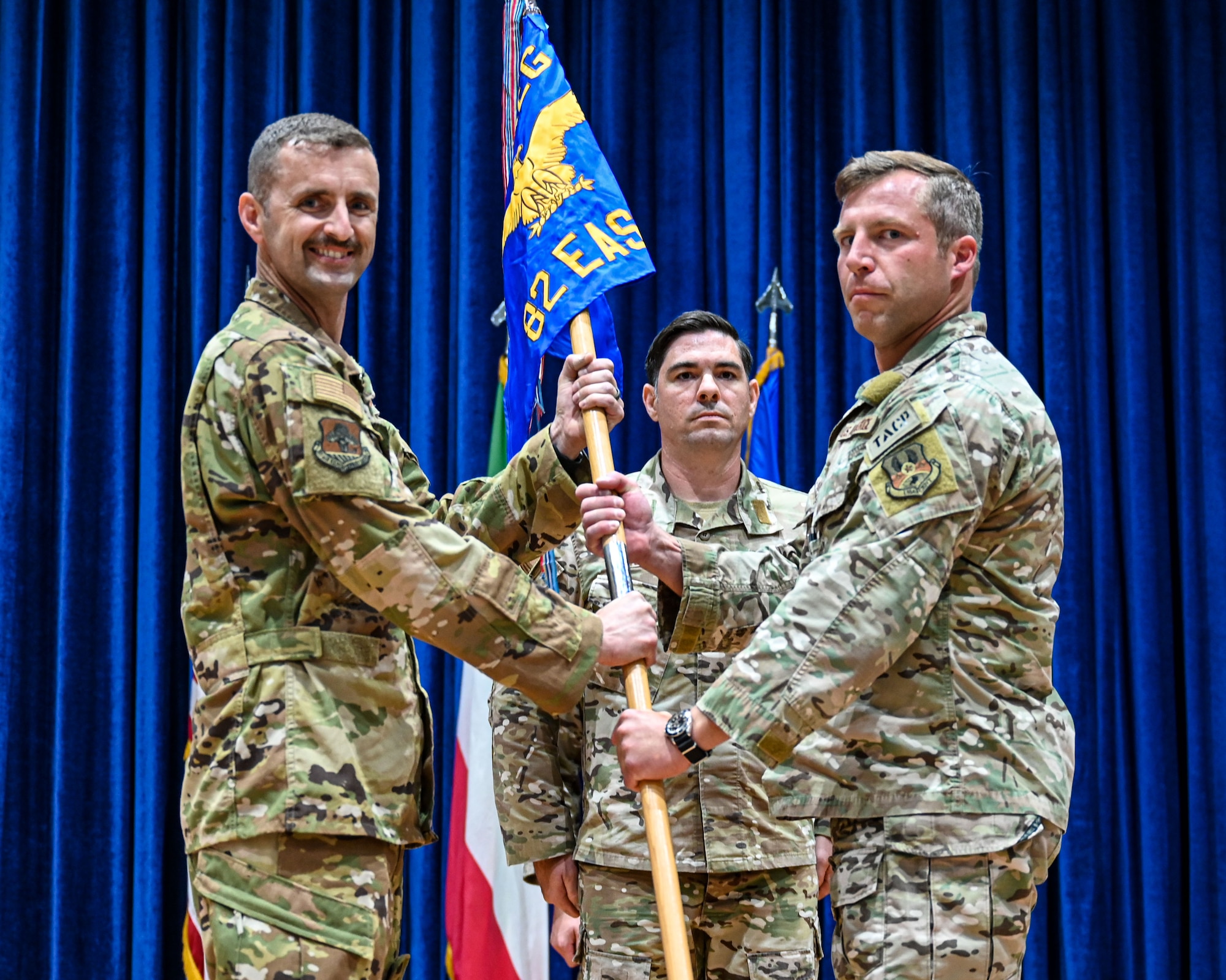Col. Rhett Brown, 387th Air Expeditionary Group commander, passes the guidon to Lt. Col. Zachary Buckallew, incoming 82nd Expeditionary Air Support Operations Squadron commander, during a change of command ceremony at Ali Al Salem Air Base, Kuwait, July 19, 2023.