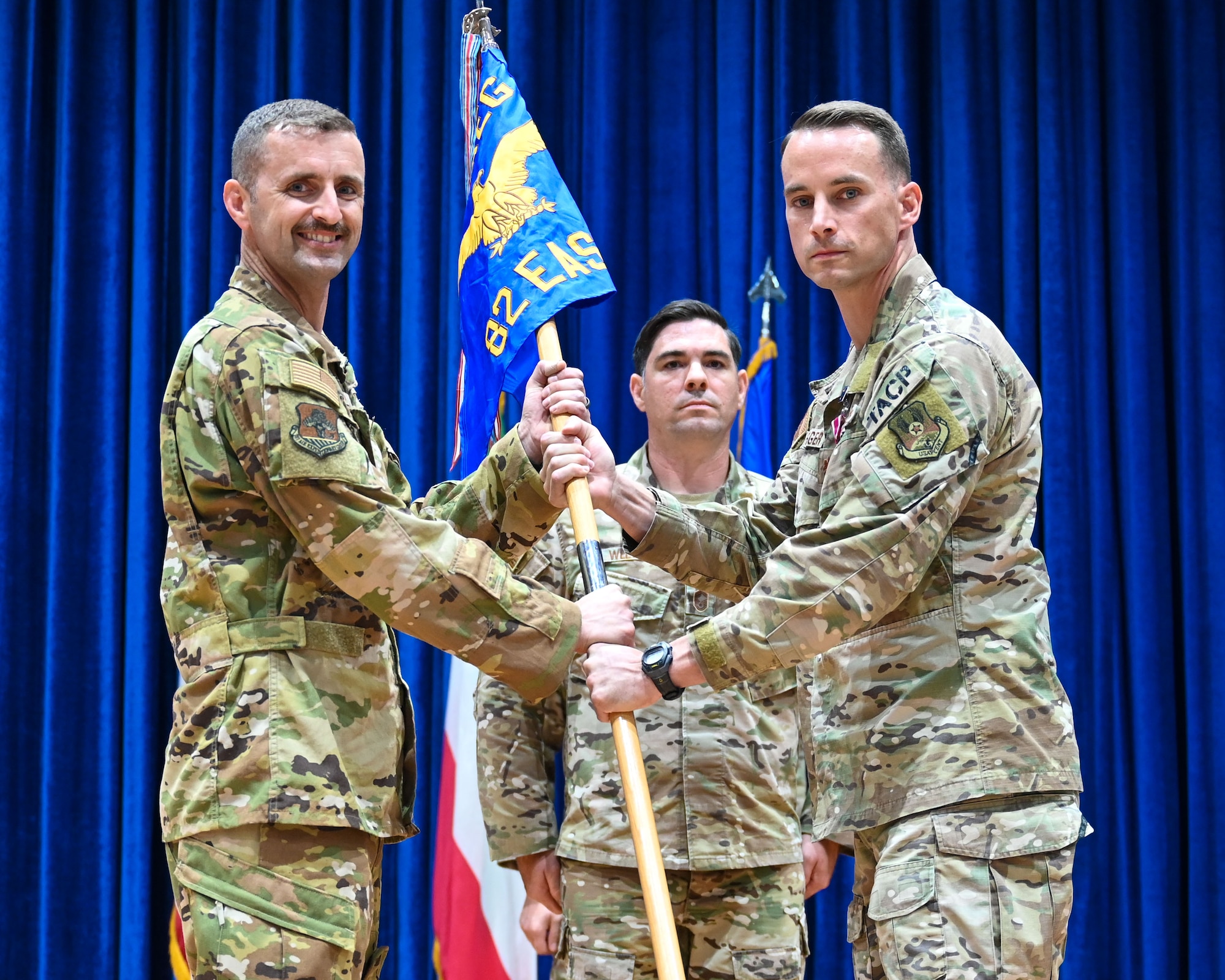 Maj. Shawn Bearinger, outgoing 82nd Expeditionary Air Support Operations Squadron commander, passes the guidon to Col. Rhett Brown, 387th Air Expeditionary Group commander during a change of command ceremony at Ali Al Salem Air Base, Kuwait, July 19, 2023.