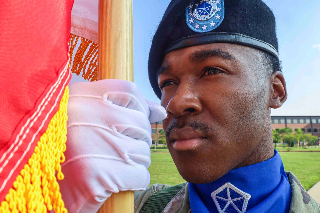 A close-up of a soldier holding a flag close to his face.