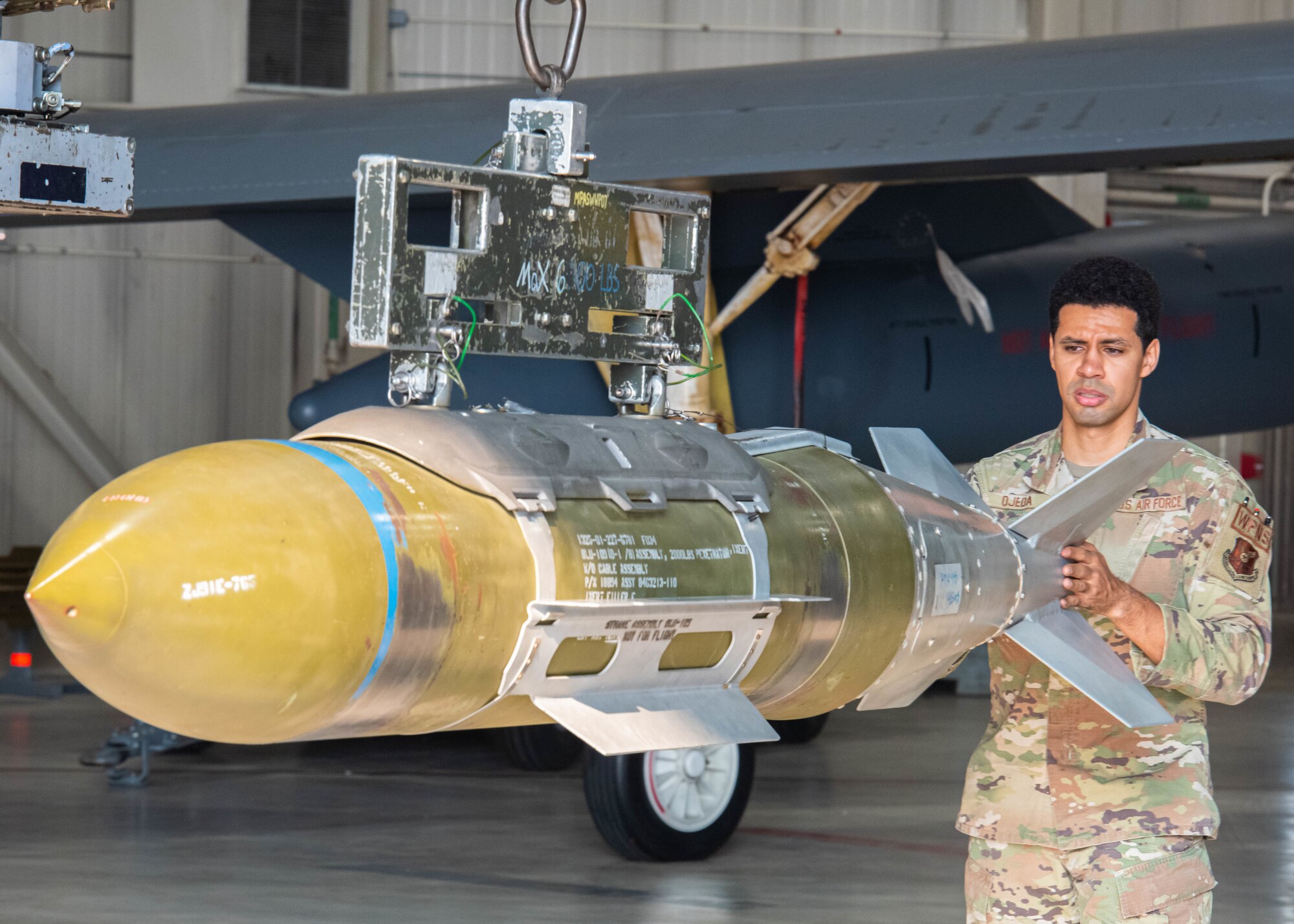Senior Airman Christian Ojeda, 5th Maintenance Group load crew member, moves an inert precision guided munition at Minot Air Force Base, North Dakota, July 14, 2023. Ojeda was preparing inert precision guided munitions for a quarterly weapons load crew competition. (U.S. Air Force photo by Airman 1st Class Kyle Wilson)