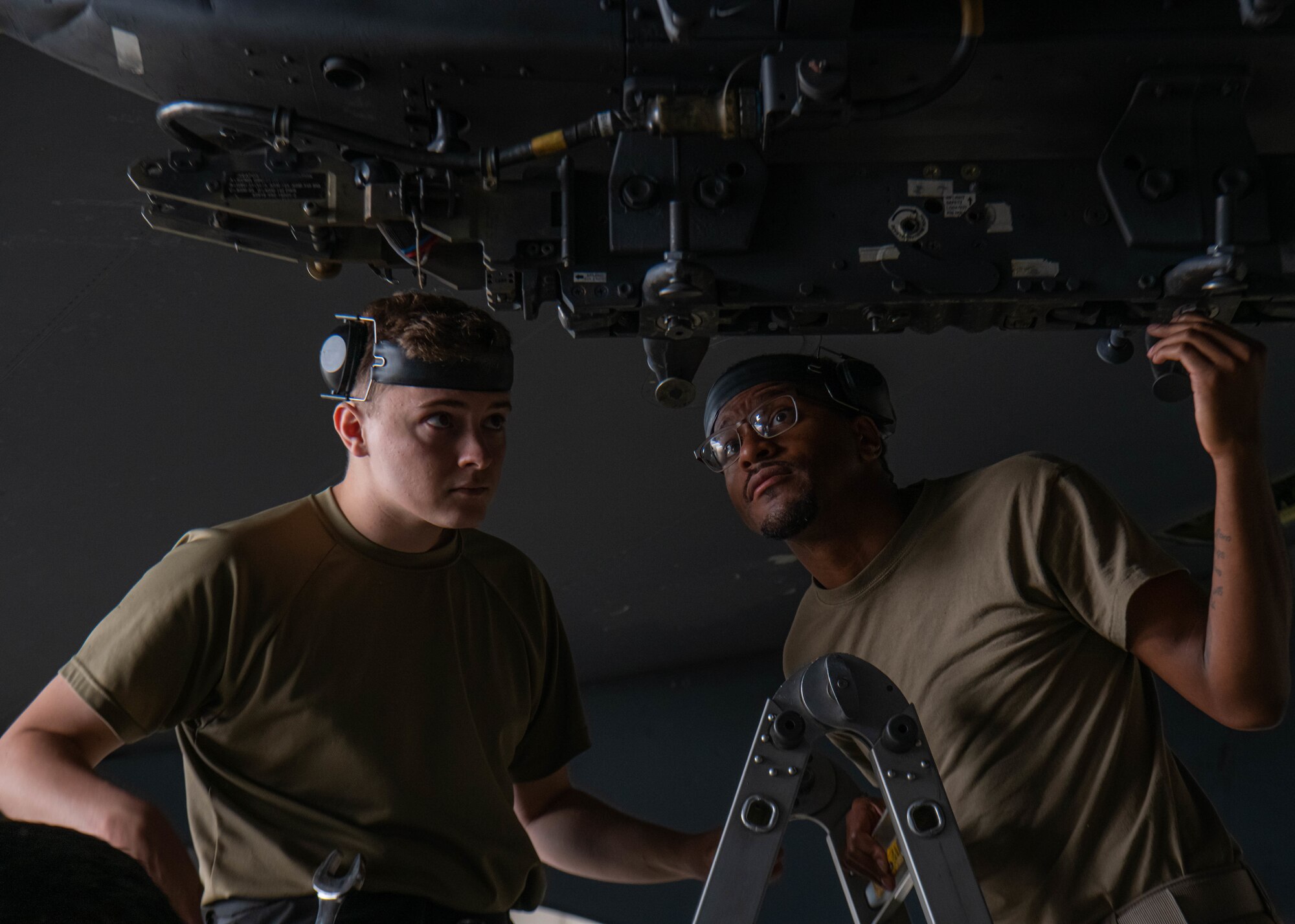 Senior Airman Cody Brittain (left) and U.S. Air Force Staff Sergeant Tony Rodgers, 5th Aircraft Maintenance Squadron load crew members, inspect the wing pylon of a B-52H Stratofortress at Minot Air Force Base, North Dakota, July 14, 2023. The B-52H Stratofortress is capable of carrying up to 70,000 pounds of munitions. (U.S. Air Force photo by Airman 1st Class Kyle Wilson)