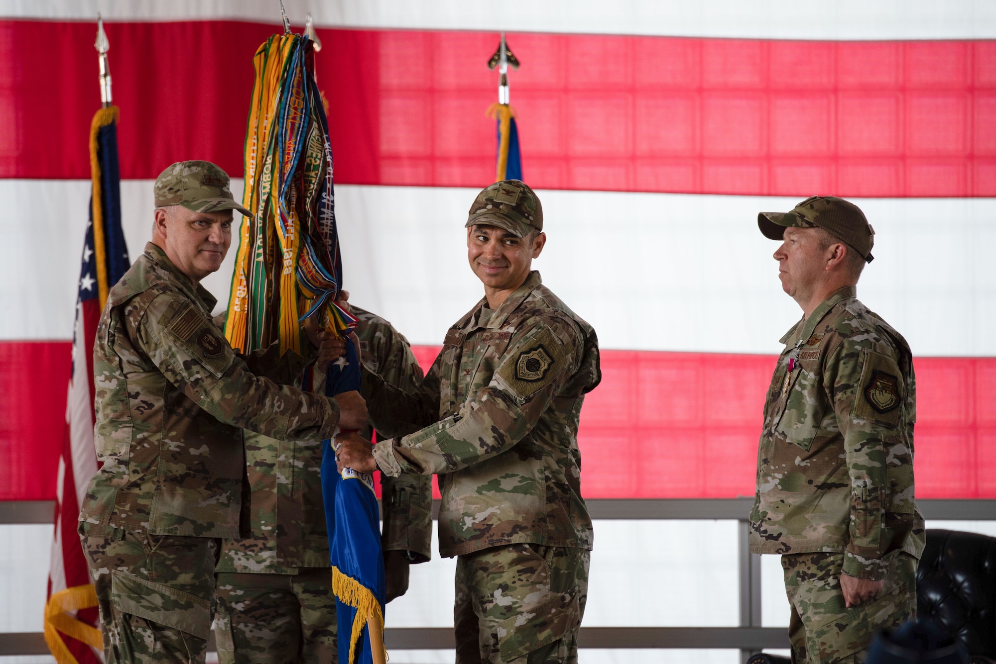 Maj. Gen. Michael Koscheski poses handing the guidon to Col. Michael Alfaro after the flag was taken from Col. Ernesto DiVittorio, signifying the passing of command.