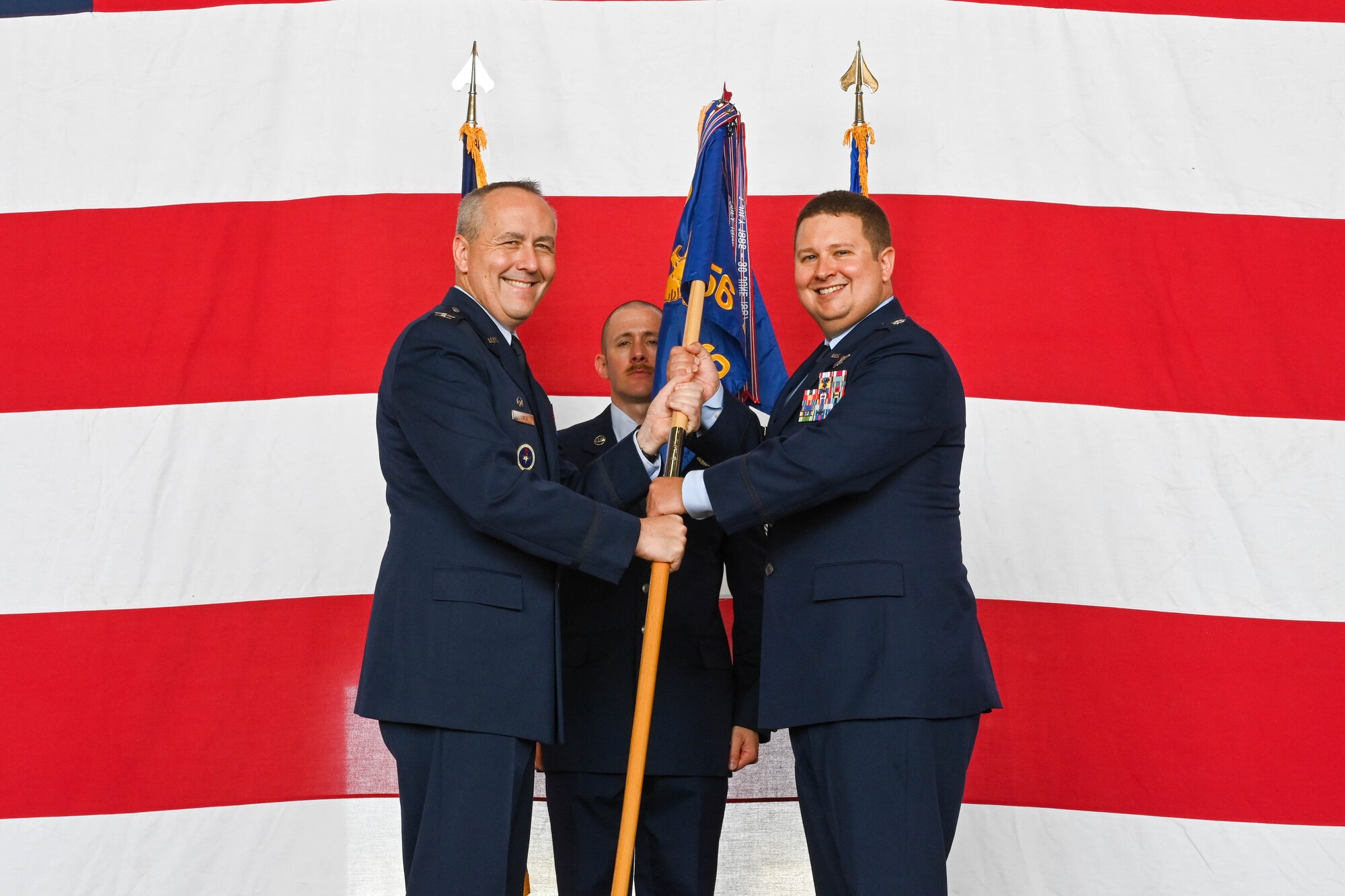 U.S. Air Force Col. Scott Linck, 97th Operations Group commander, passes the 56th Air Refueling Squadron (ARS) guidon to Lt. Col. Peter Culbert, 56th ARS commander, during a change of command ceremony at Altus Air Force Base (AFB), Oklahoma, June 2, 2023. The 56th ARS is home to the KC-46 Pegasus. (U.S. Air Force photo by Senior Airman Trenton Jancze)