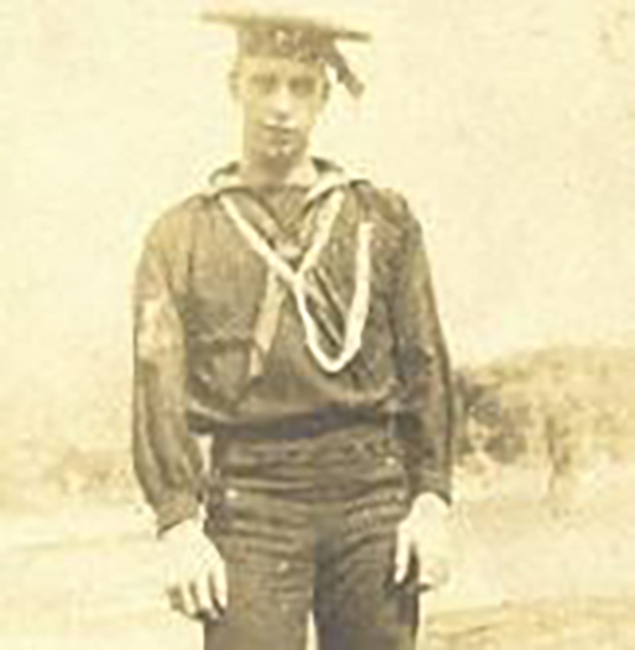 A man in a uniform and cap poses for a photo.