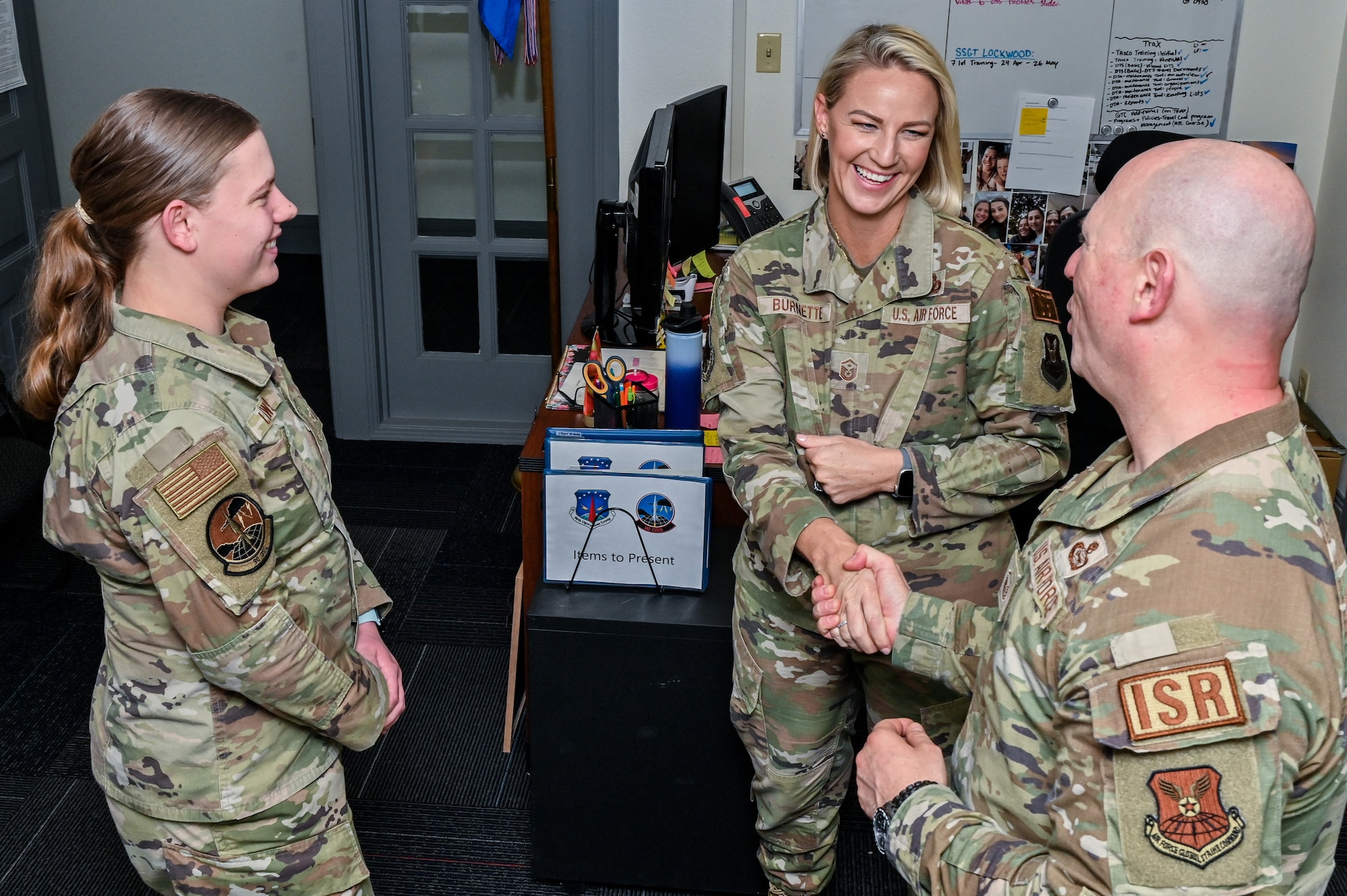 Master Sgt. Britni Burnette (center), 90th Operations Group first sergeant, talks with Master Sgt. Kevin Hale (right), 90th Operations Support Squadron senior enlisted leader, and Airman Jenna Lawson, 90 OSS commander’s support staff, in the 90th Operations Group headquarters building on F.E. Warren Air Force Base, Wyoming, May 5, 2023. Burnette’s efforts as 90 OG first sergeant earned her the Air Force Global Strike Command’s award for “Outstanding First Sergeant of the Year.” (U.S. Air Force photo by Joseph Coslett Jr.)