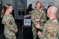 Master Sgt. Britni Burnette (center), 90th Operations Group first sergeant, talks with Master Sgt. Kevin Hale (right), 90th Operations Support Squadron senior enlisted leader, and Airman Jenna Lawson, 90 OSS commander’s support staff, in the 90th Operations Group headquarters building on F.E. Warren Air Force Base, Wyoming, May 5, 2023. Burnette’s efforts as 90 OG first sergeant earned her the Air Force Global Strike Command’s award for “Outstanding First Sergeant of the Year.” (U.S. Air Force photo by Joseph Coslett Jr.)