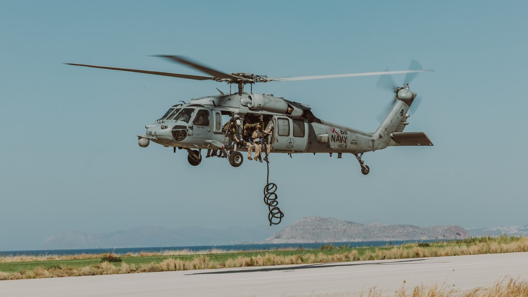 U.S. Marines with Force Company, 2d Reconnaissance Battalion, 2d Marine Division, under tactical control of Task Force 61/2, unfurl a rope out of a MH-60S helicopter in preparation to conduct fast rope training in Souda Bay, Greece on July 19, 2023. Task Force 61/2.5 provides naval and joint force commanders with dedicated multi-domain reconnaissance and counter reconnaissance (RXR) capabilities. (U.S. Marine Corps photo by Lance Cpl. Emma Gray)