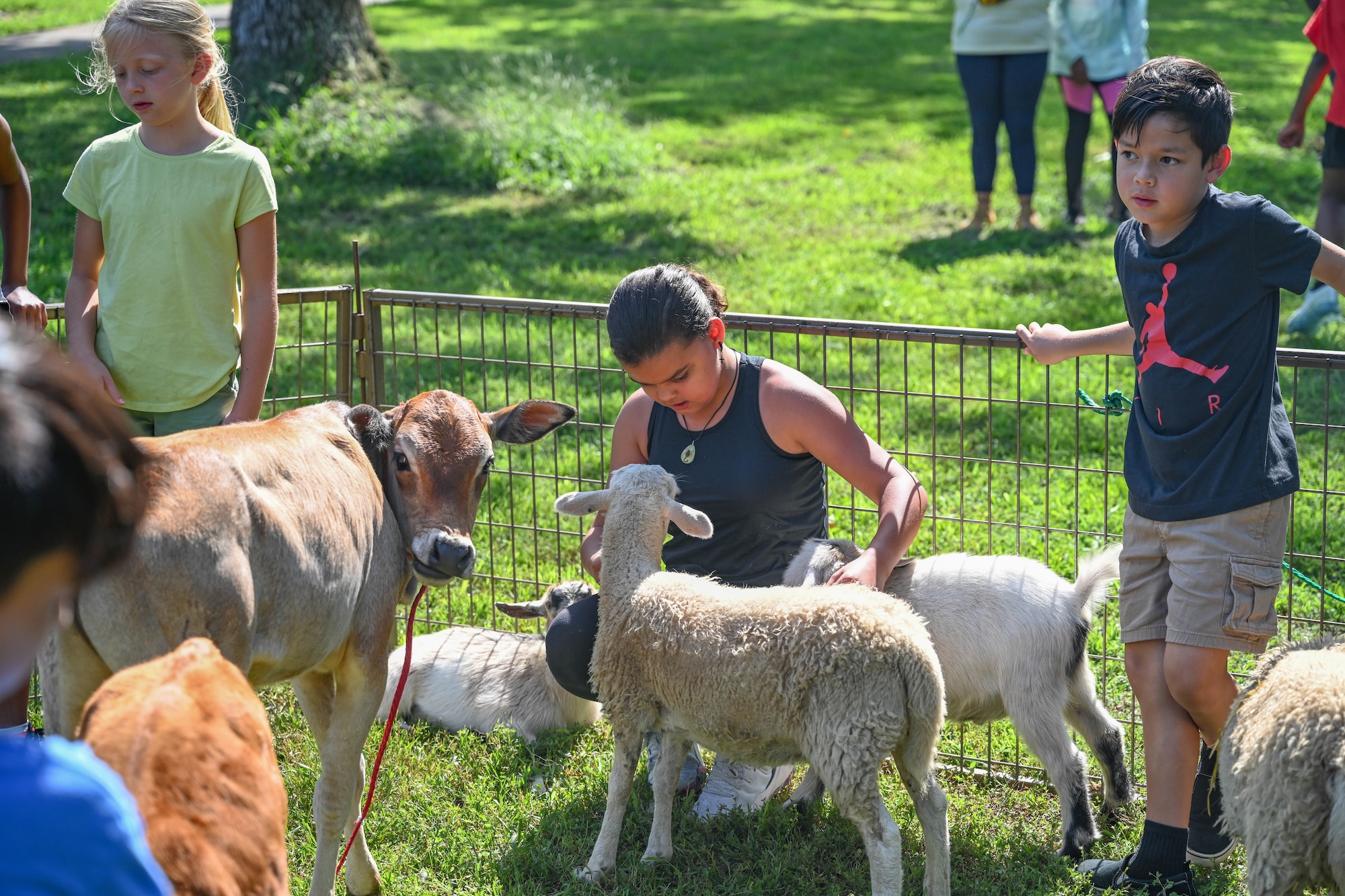 A group of children interact with petting zoo animals