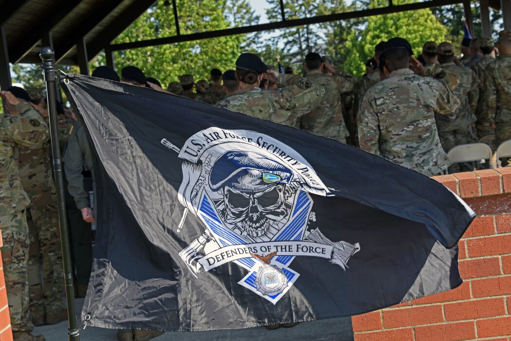 A U.S. Air Force Security Police flag flies during the 627th Security Forces Squadron change of command ceremony at Joint Base Lewis-McChord, Washington, July 20, 2023. The mission of the 627th SFS is to defend the McChord Field flightline, execute Phoenix Raven flyaway security operations in support of U.S. Transportation Command, and lead combat arms training for JBLM Airmen. (U.S. Air Force photo by Staff Sgt. Zoe Thacker)