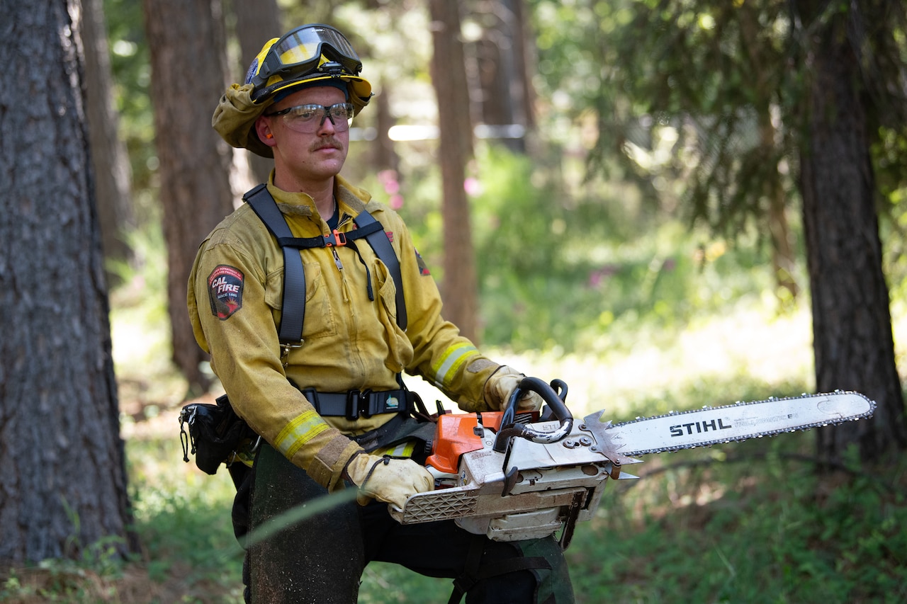 A man is photographed holding a chainsaw.