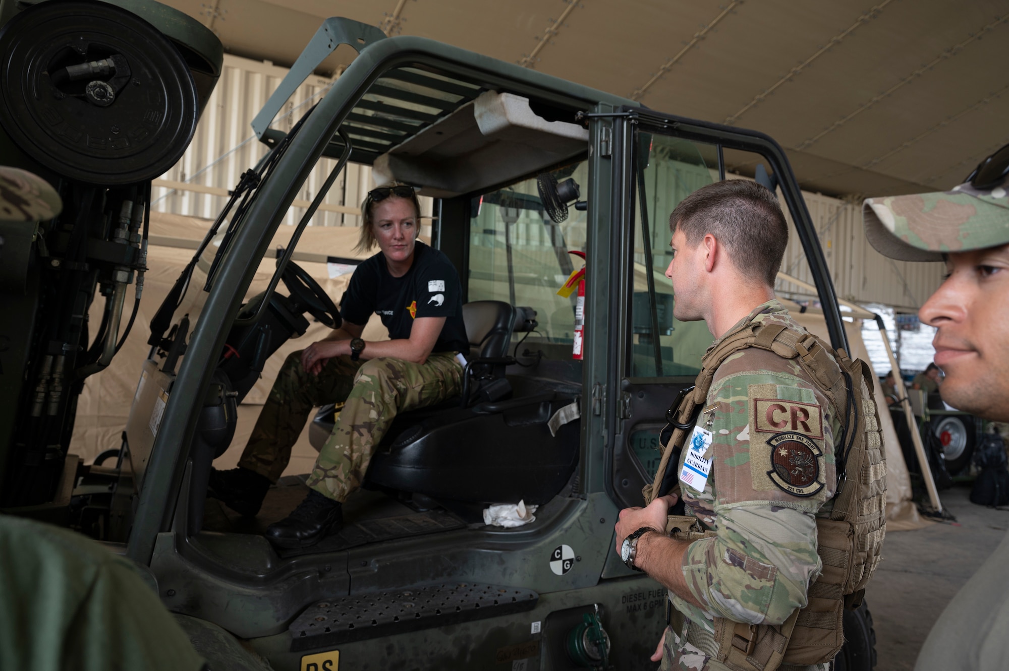 U.S. Air Force Maj. Ben Rofe, 321st Contingency Response Squadron director of operations coordinates cargo movement with a Royal Canadian Air Force member during Mobility Guardian 23 at Andersen Air Force Base, Guam, July 8, 2023. The Mobility Air Forces role in providing the meaningful maneuver of forces throughout the theater underscores the necessity of logistics and realistic interoperability in the region. (U.S. Air Force photo by Staff Sgt. Malissa Lott)