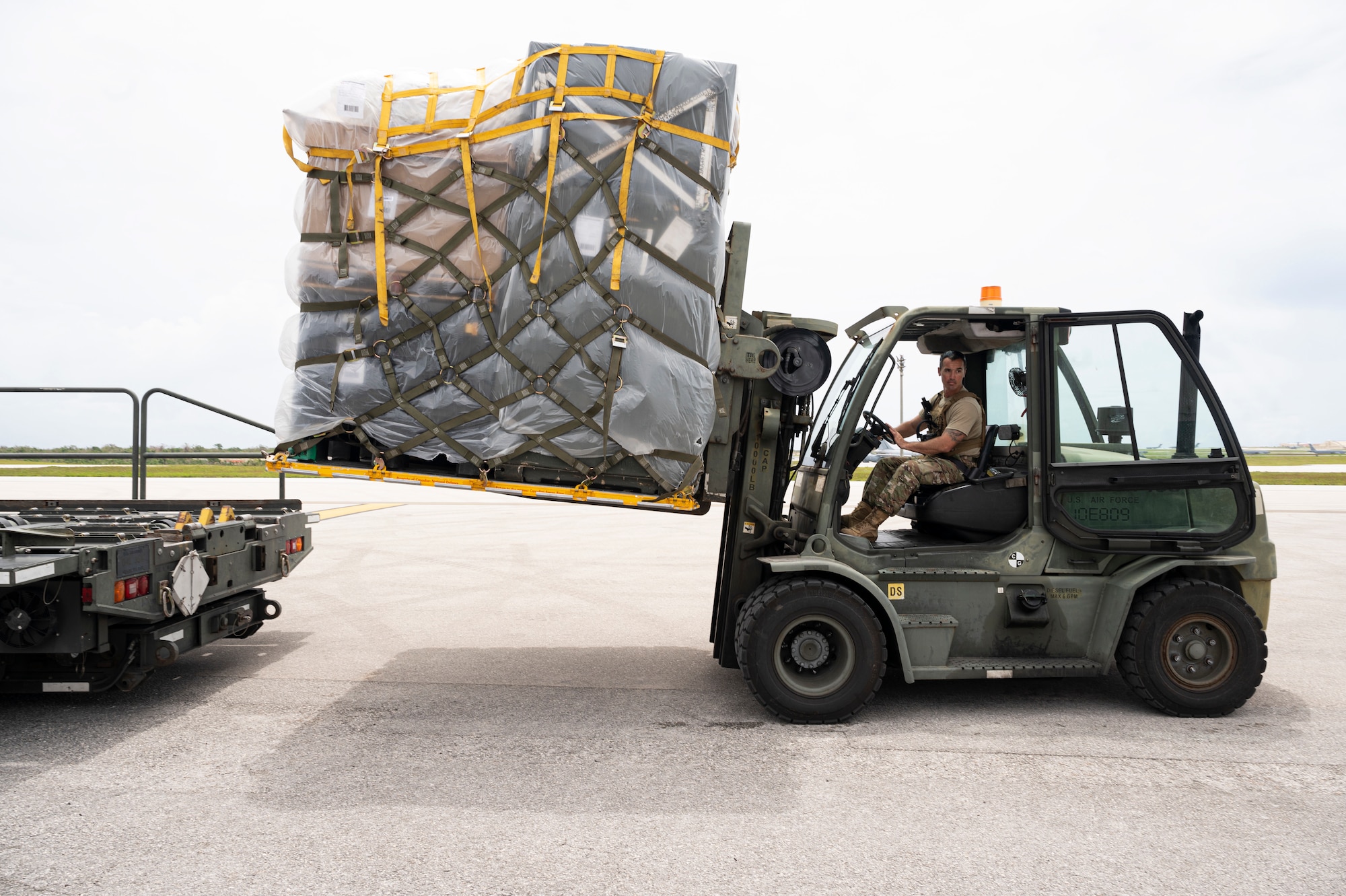 A U.S. Air Force Airman moves cargo during Mobility Guardian 23, at Andersen Air Force Base, Guam, June 8, 2023. 3,000 personnel directly supported the large-scale mobility exercise, which provided the maneuver of more than 15,000 U.S. and international forces associated with other exercises across the Indo-Pacific held in the same timeframe. (U.S. Air Force photo by Staff Sgt. Malissa Lott)