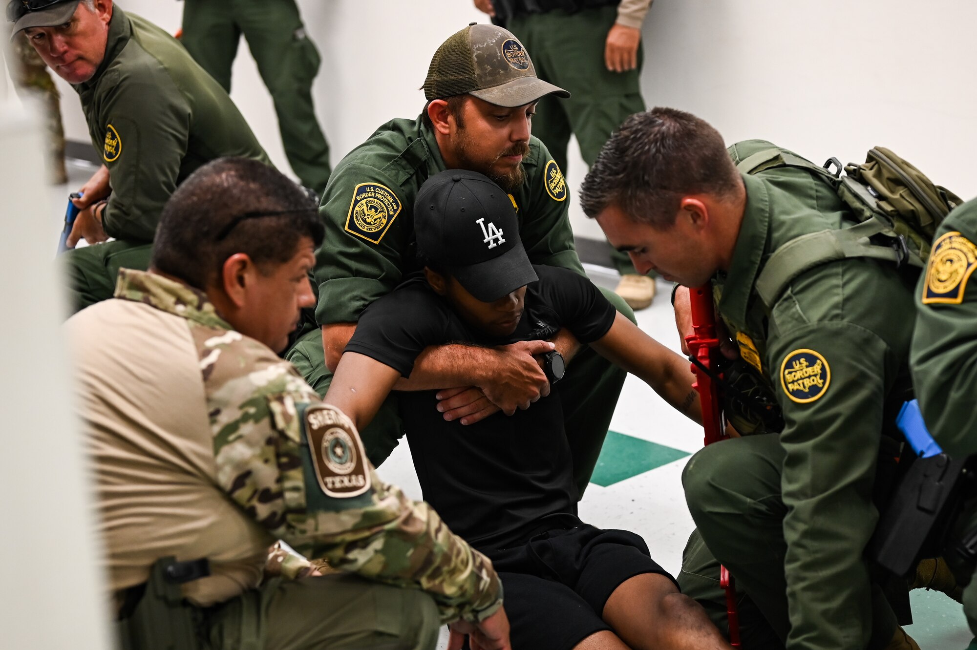Customs and border protection (CBP) border patrol officers pick up a simulated victim during a training exercise alongside Laughlin Air Force Base's Security Forces at San Felipe Memorial Middle School, Texas, July 12, 2023.