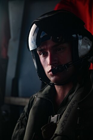 U.S. Navy Petty Officer 1st Class William Bennett, an aviation rescue swimmer assigned to Helicopter Sea Combat Squadron 25, receives a message aboard MH-60S Knighthawk on Andersen Air Force Base, Guam, July 18, 2023. During the mission, the crew was tasked for a search and rescue mission to aid an injured hiker on the island.  (U.S. Air Force photo by Tech. Sgt. Michael Cossaboom)