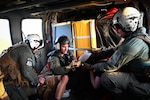 U.S. Navy Petty Officer 1st Class William Bennett Petty Officer 2nd Class Ryan Horn, and Petty Officer 3rd Class Damian Maxilom, all aviation rescue swimmer assigned to Helicopter Sea Combat Squadron 25, tend to an injured hiker aboard an MH-60S Knighthawk on Guam, July 18, 2023. The crew treated the injuries of the hiker before safely transporting her to a local hospital. (U.S. Air Force photo by Tech. Sgt. Michael Cossaboom)