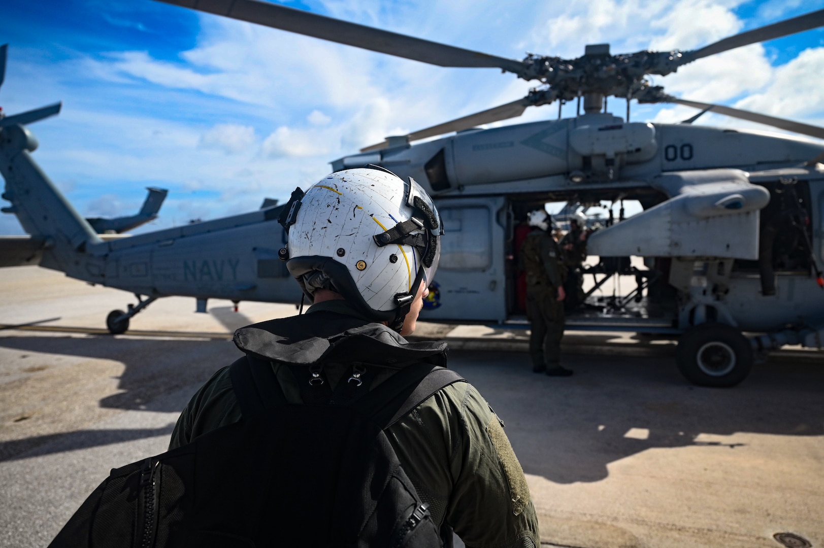 U.S. Navy Petty Officer 3rd Class Damian Maxilom, an aviation rescue swimmer assigned to Helicopter Sea Combat Squadron 25 prepares to board a MH-60S Knighthawk on Andersen Air Force Base, Guam, July 18, 2023. While flying a multinational Maritime Personnel Recovery training event during Mobility Guardian 23, the crew was called to rescue a hiker who had fallen off a mountainside. MG23 is a mobility exercise held across a 3,000-mile area intended to deepen interoperability with U.S. Allies and partners, bolstering the collective ability to support a free and open Indo-Pacific area. (U.S. Air Force photo by Tech. Sgt. Michael Cossaboom)